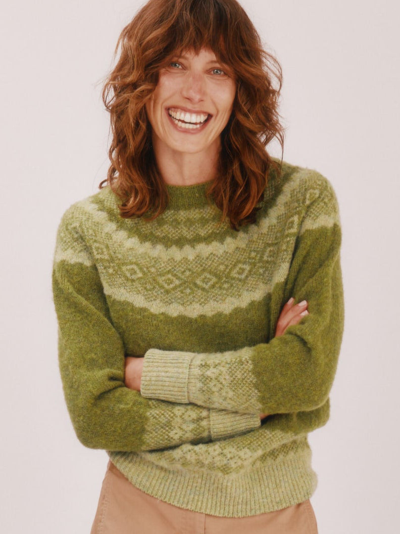 Model wearing a Bosie Knitwear Borealis Yoke Brushed Fair Isle Women's Lambswool Sweater  in colour Olive Grove Green.