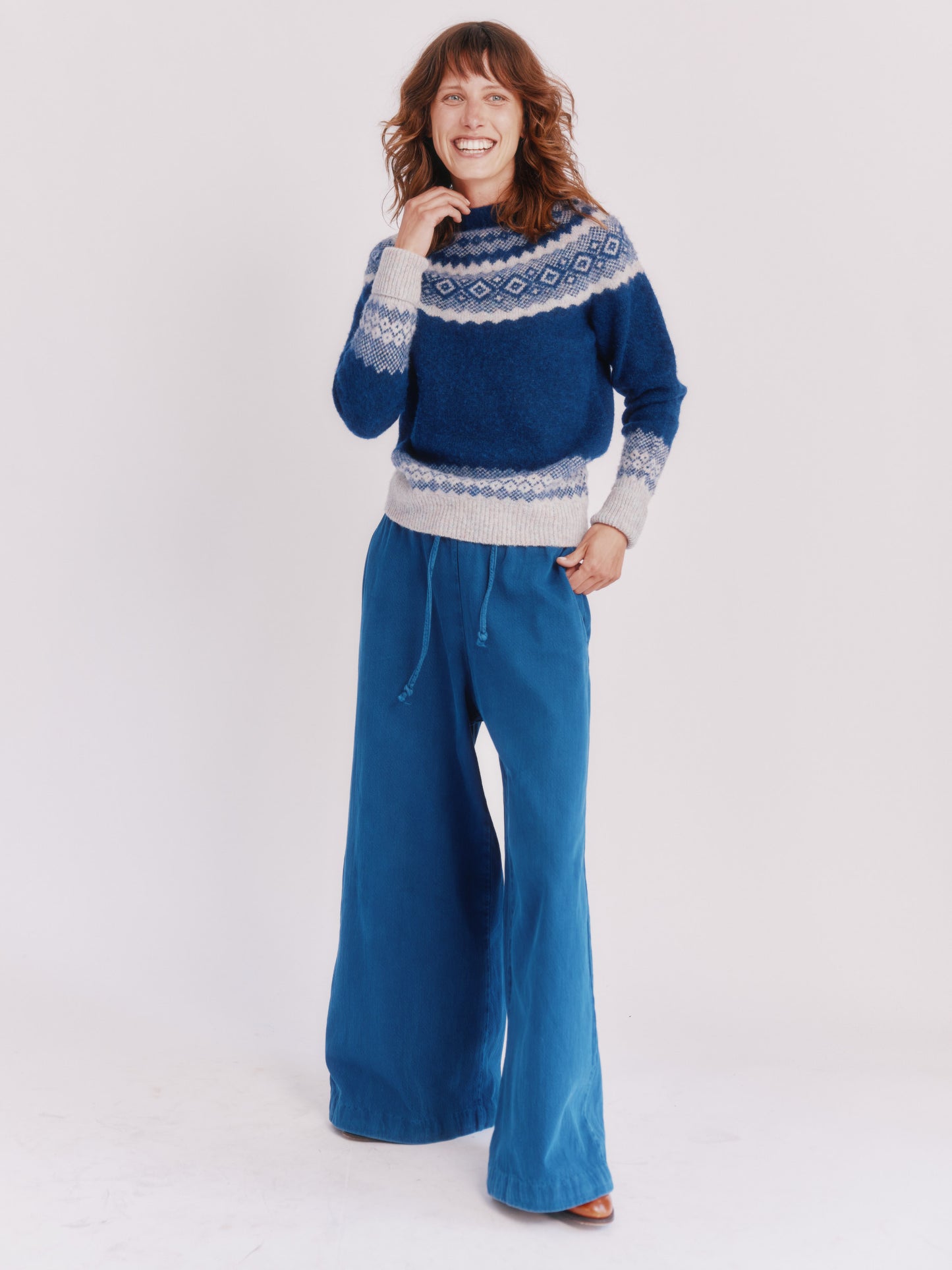 Model wearing a Bosie Knitwear Borealis Yoke Brushed Fair Isle Women's Lambswool Sweater in colour Starnight Blue.