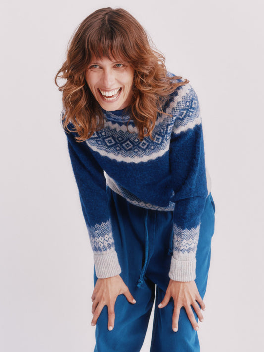 Model wearing a Bosie Knitwear Borealis Yoke Brushed Fair Isle Women's Lambswool Sweater in colour Starnight Blue.