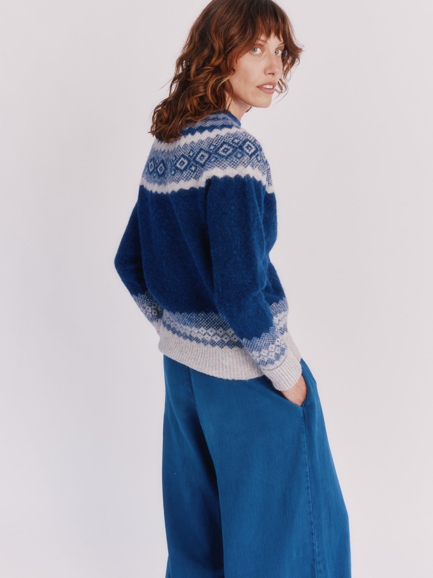 Model wearing a Bosie Knitwear Borealis Yoke Brushed Fair Isle Women's Lambswool Sweater in colour Starnight Blue.