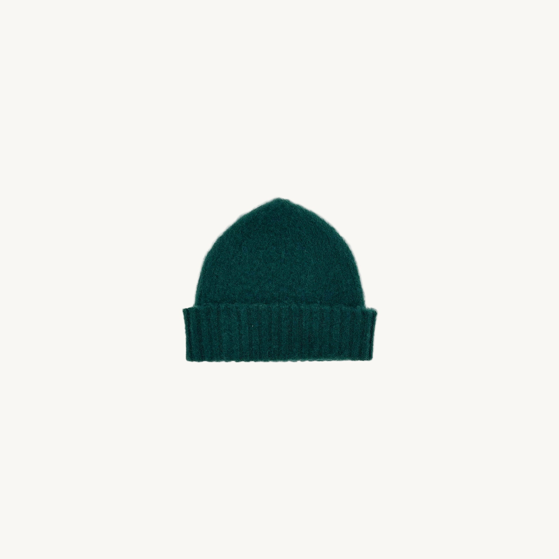 Flat bed photograph of Bosie Brushed Shetland Wool Beanie Hat in the colour Forest Green