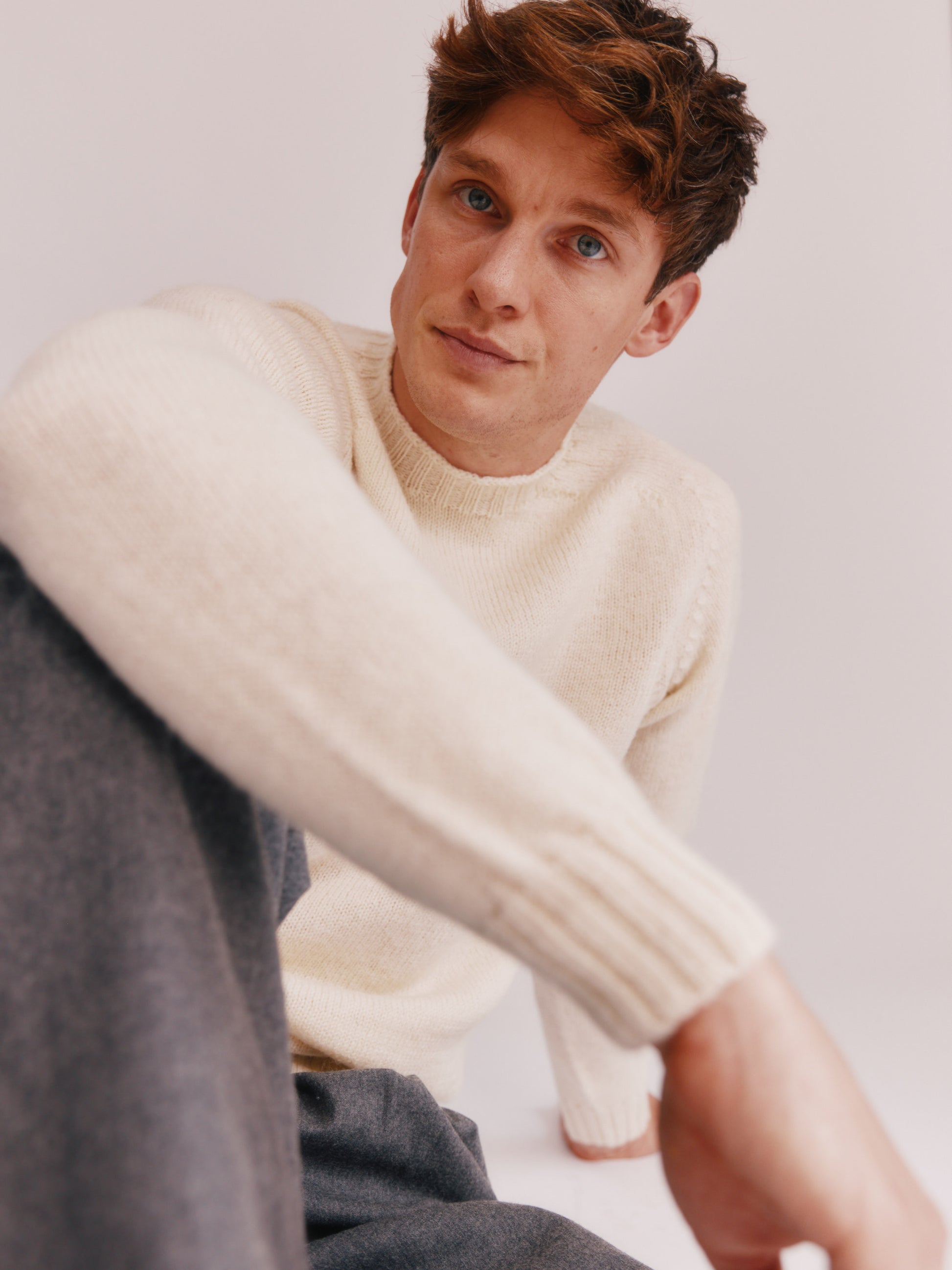 Photograph of a model wearing a 
Bosie Knitwear Harley of Scotland undyed seamless saddle shoulder men's Sherpa 2 ply Voe True Shetland sweater jumper in Ecru White.