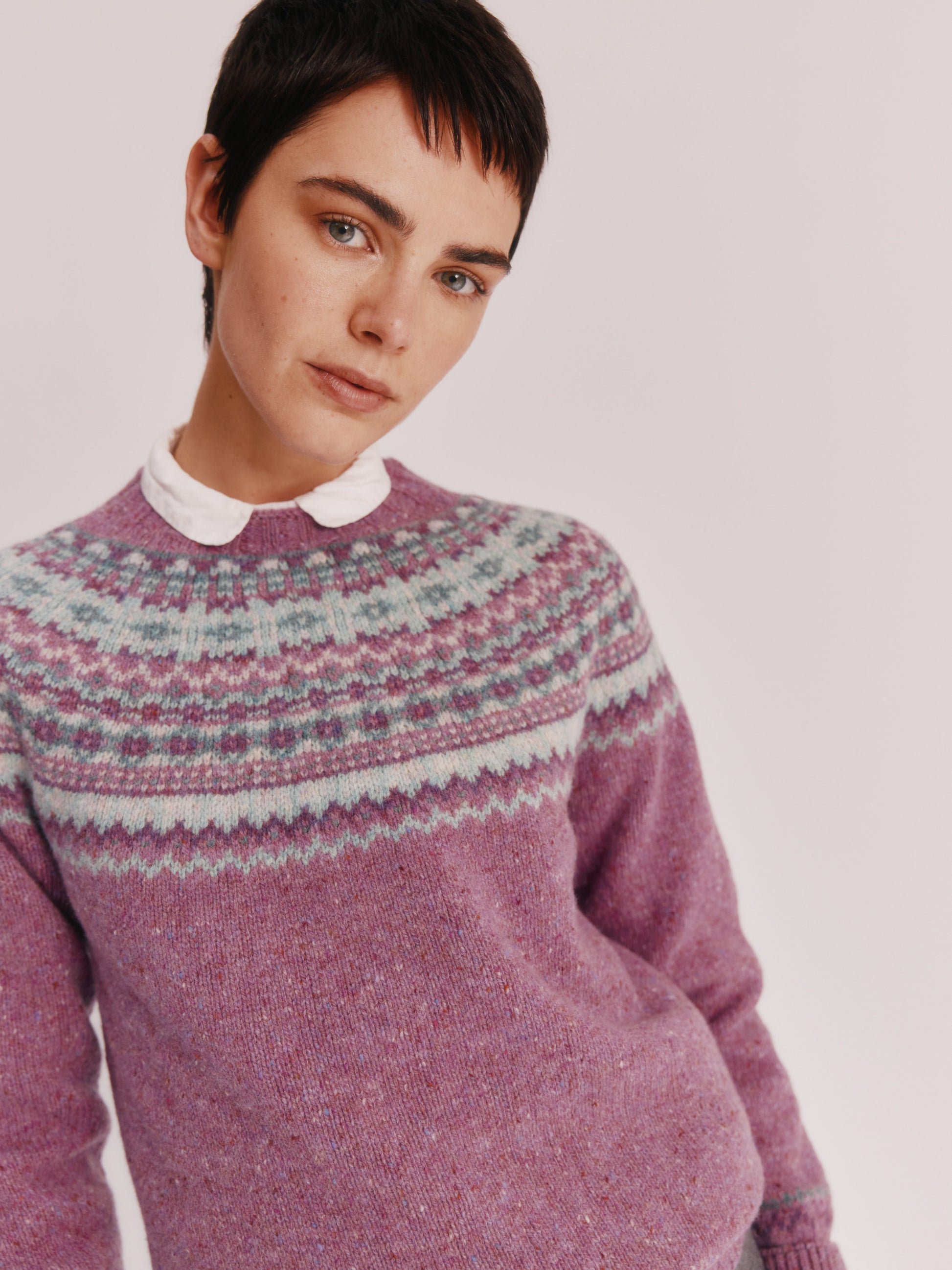 Model wearing a Bosie Knitwear Crofter Yoke Fair Isle Glenugie Nep Women's Sweater in colour Shuna Purple.