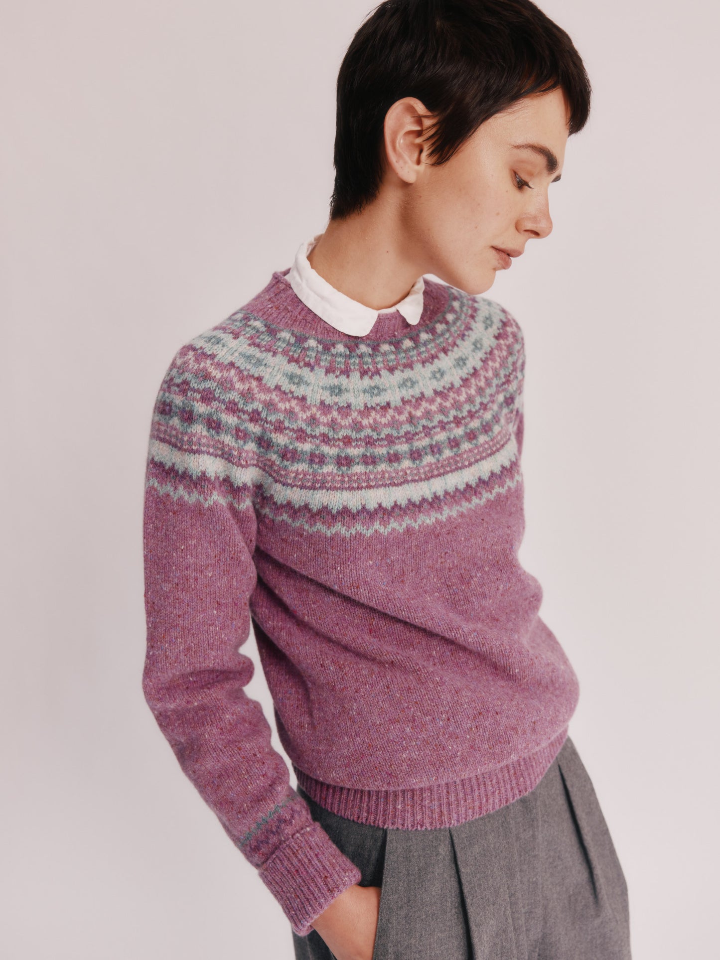 Model wearing a Bosie Knitwear Crofter Yoke Fair Isle Glenugie Nep Women's Sweater in colour Shuna Purple.
