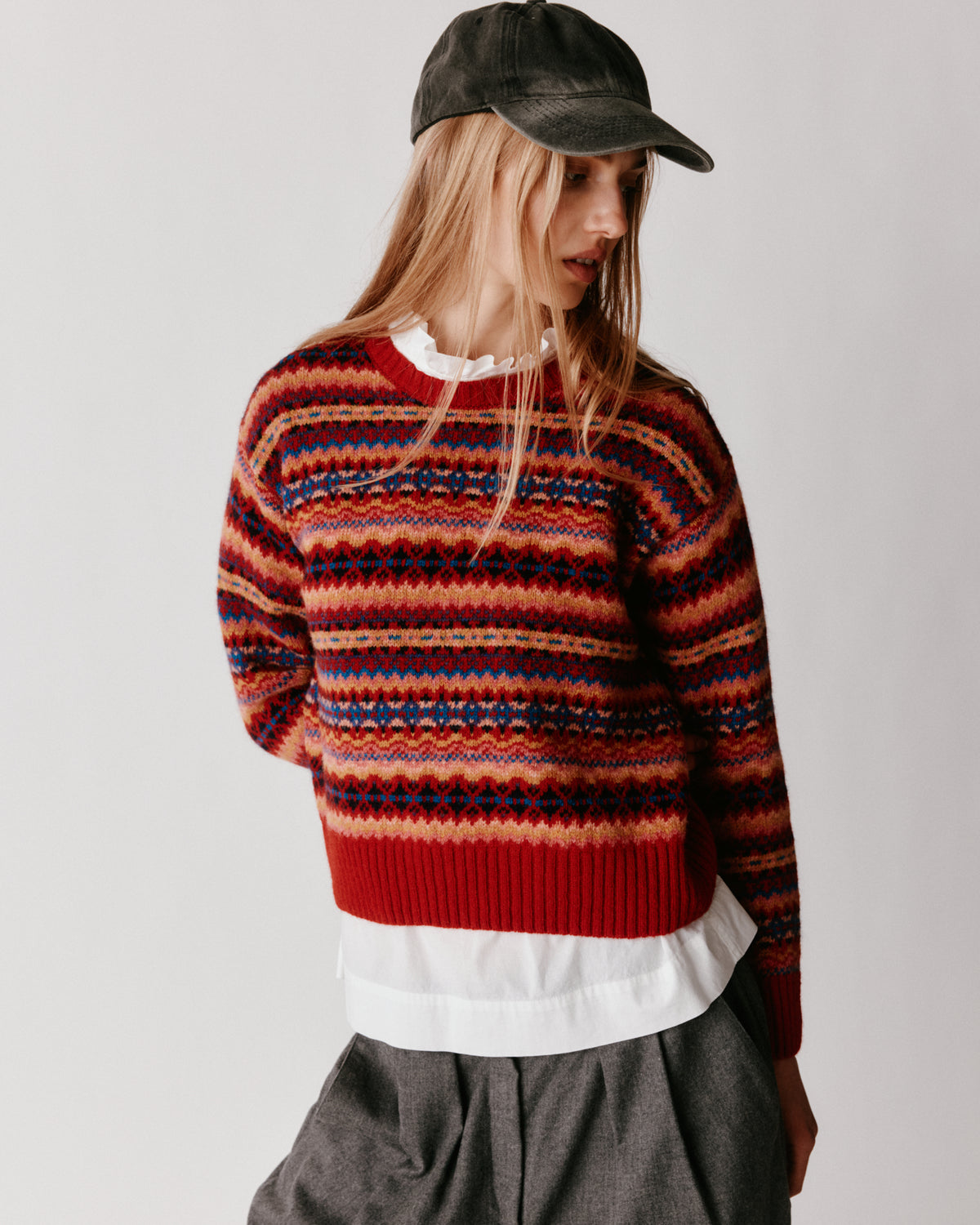 A model wearing a Bosie Cropped Allover Fair Isle Women's Sweater in colour French Red.