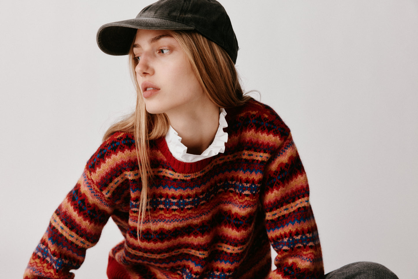 A model wearing a Bosie Cropped Allover Fair Isle Women's Sweater in colour French Red.
