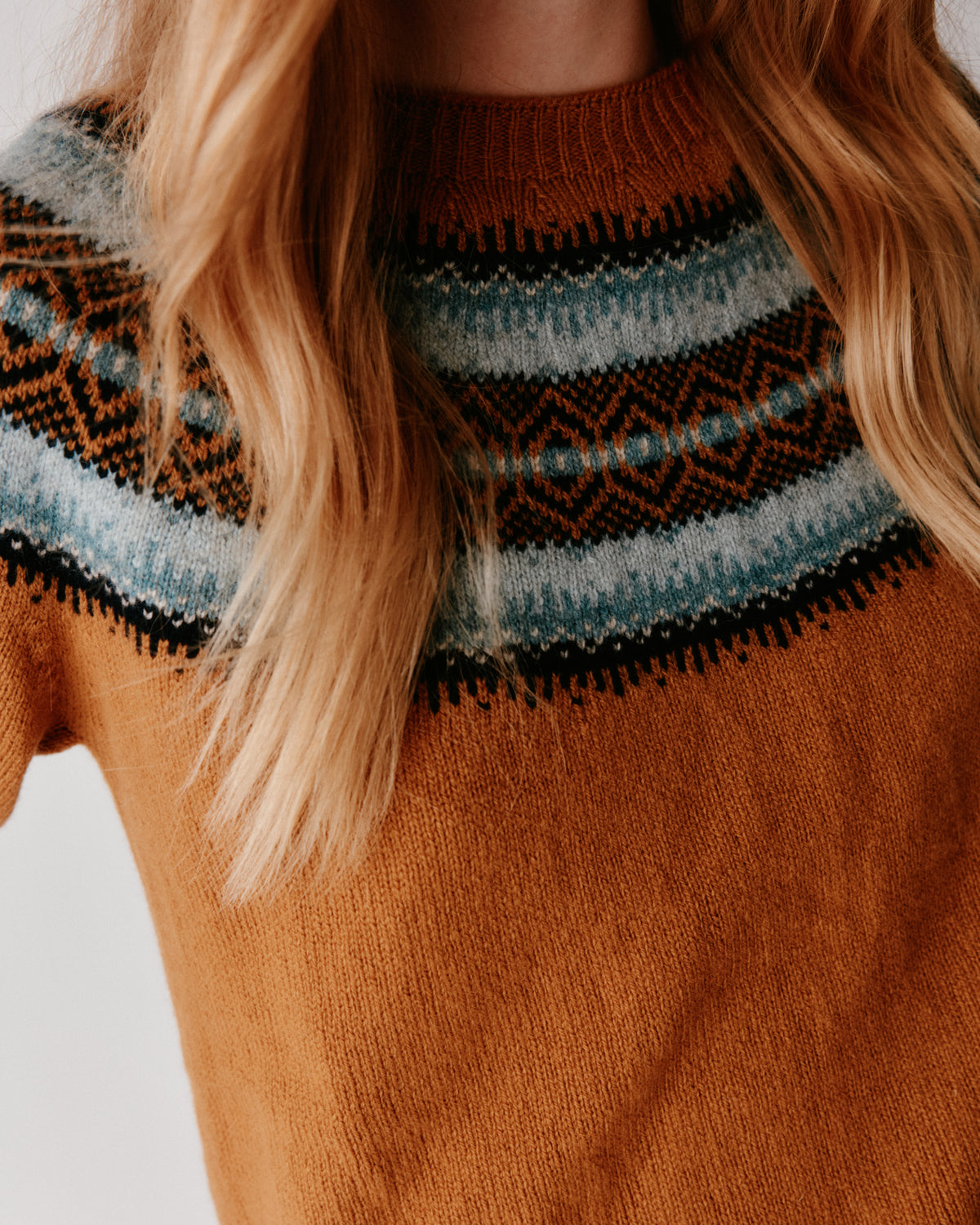 A woman wearing a Bosie Fair Isle Geelong Women's Sweater in colour Chai