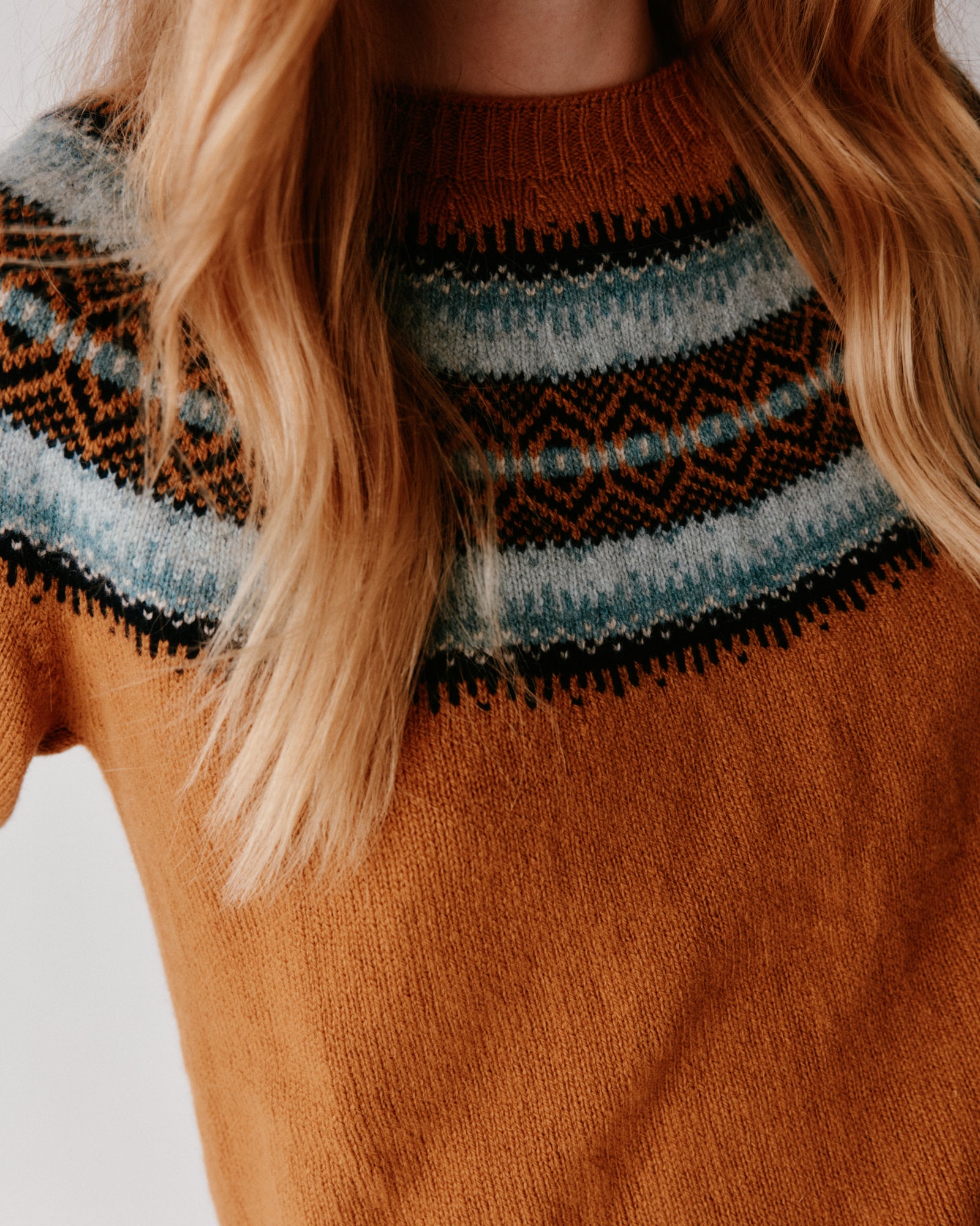 A woman wearing a Bosie Fair Isle Geelong Women's Sweater in colour Chai