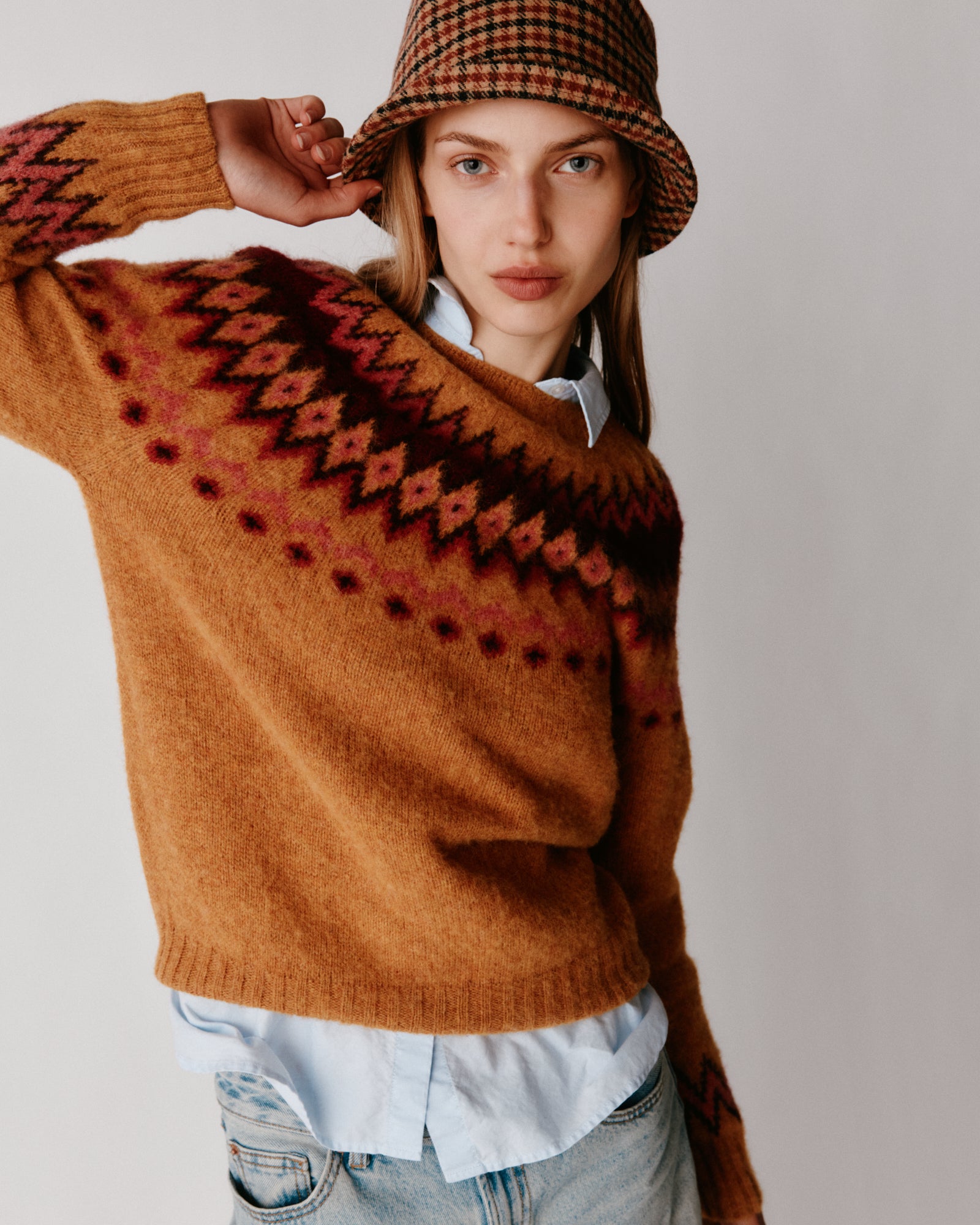A model wearing a Bosie Fjord Yoke Brushed Fair Isle Women's Lambswool Sweater in colour Gold Dust / Cummin.