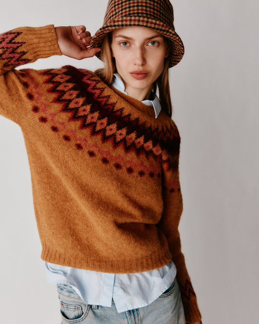 A model wearing a Bosie Fjord Yoke Brushed Fair Isle Women's Lambswool Sweater in colour Gold Dust / Cummin.