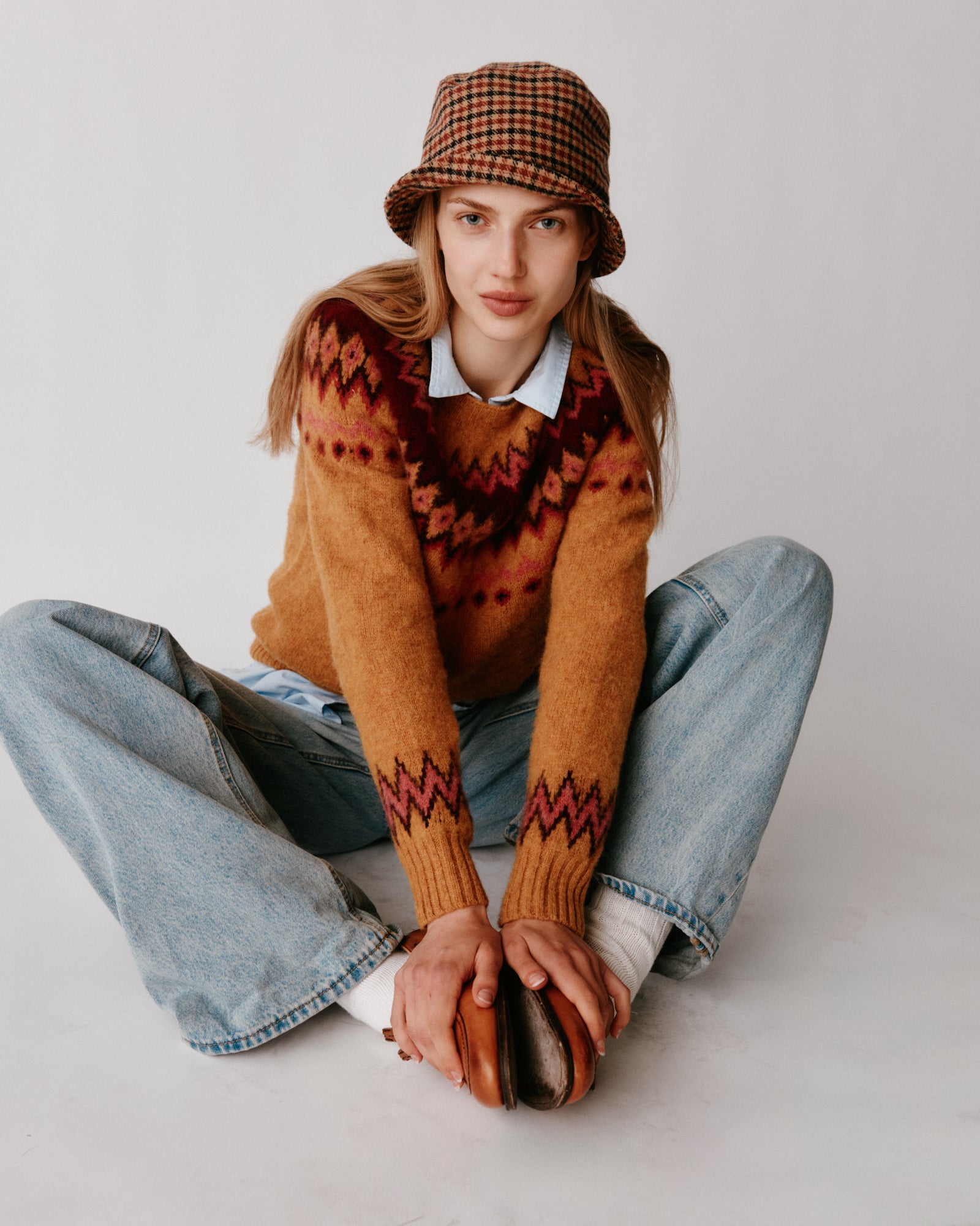 A model wearing a Bosie Fjord Yoke Brushed Fair Isle Women's Lambswool Sweater in colour Gold Dust / Cummin.