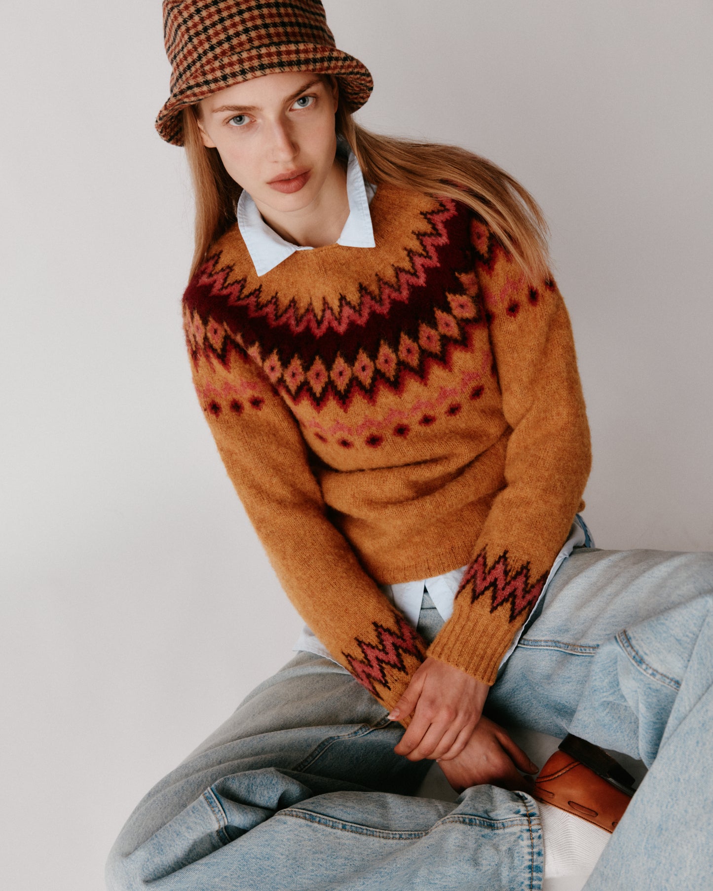 A model wearing a Bosie Fjord Yoke Brushed Fair Isle Women's Lambswool Sweater in colour Gold Dust / Cummin.