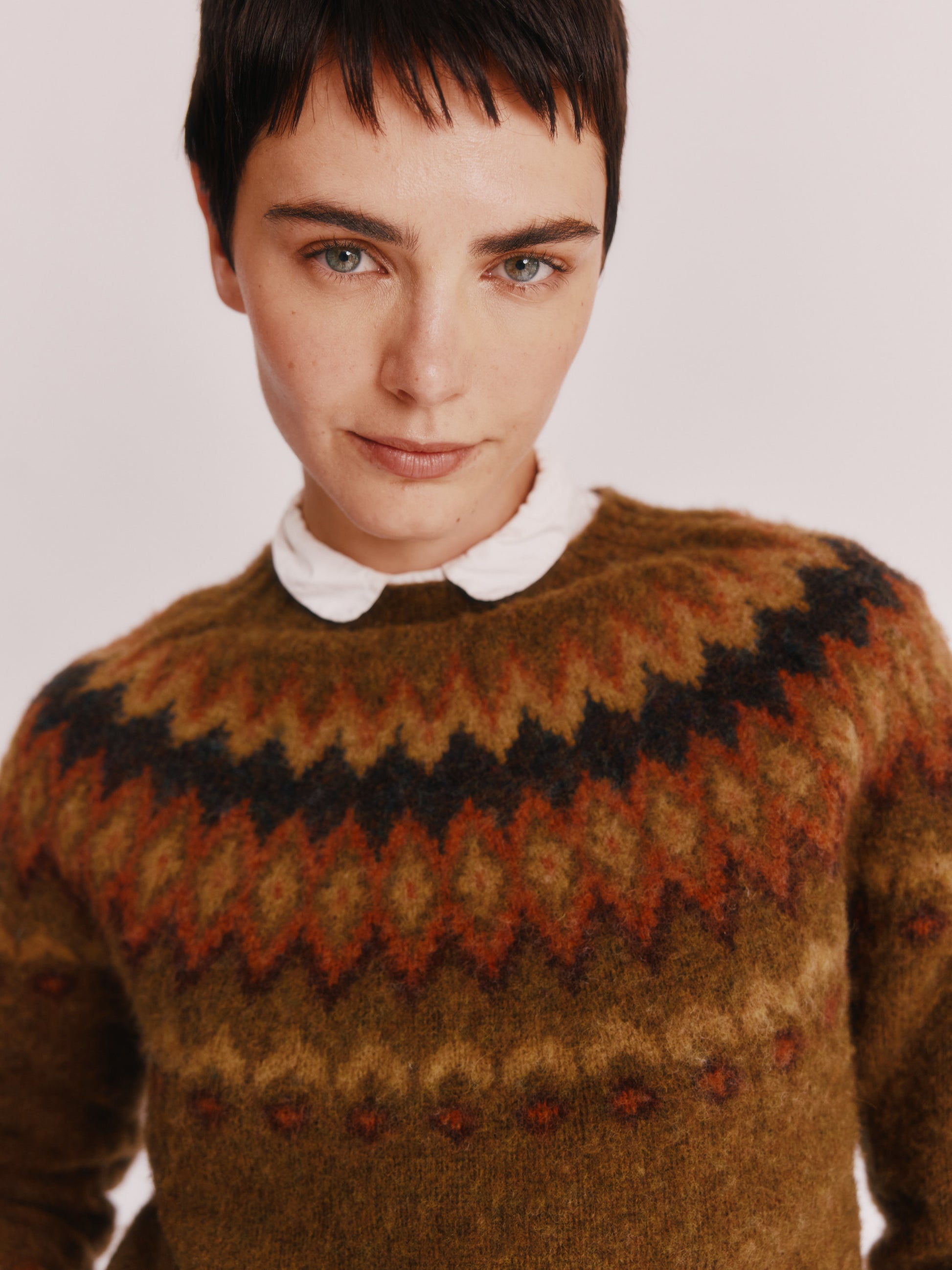 Model wearing a Bosie Knitwear Fjord Yoke Brushed Fair Isle Women's Lambswool Sweater in colour Dark Olive.