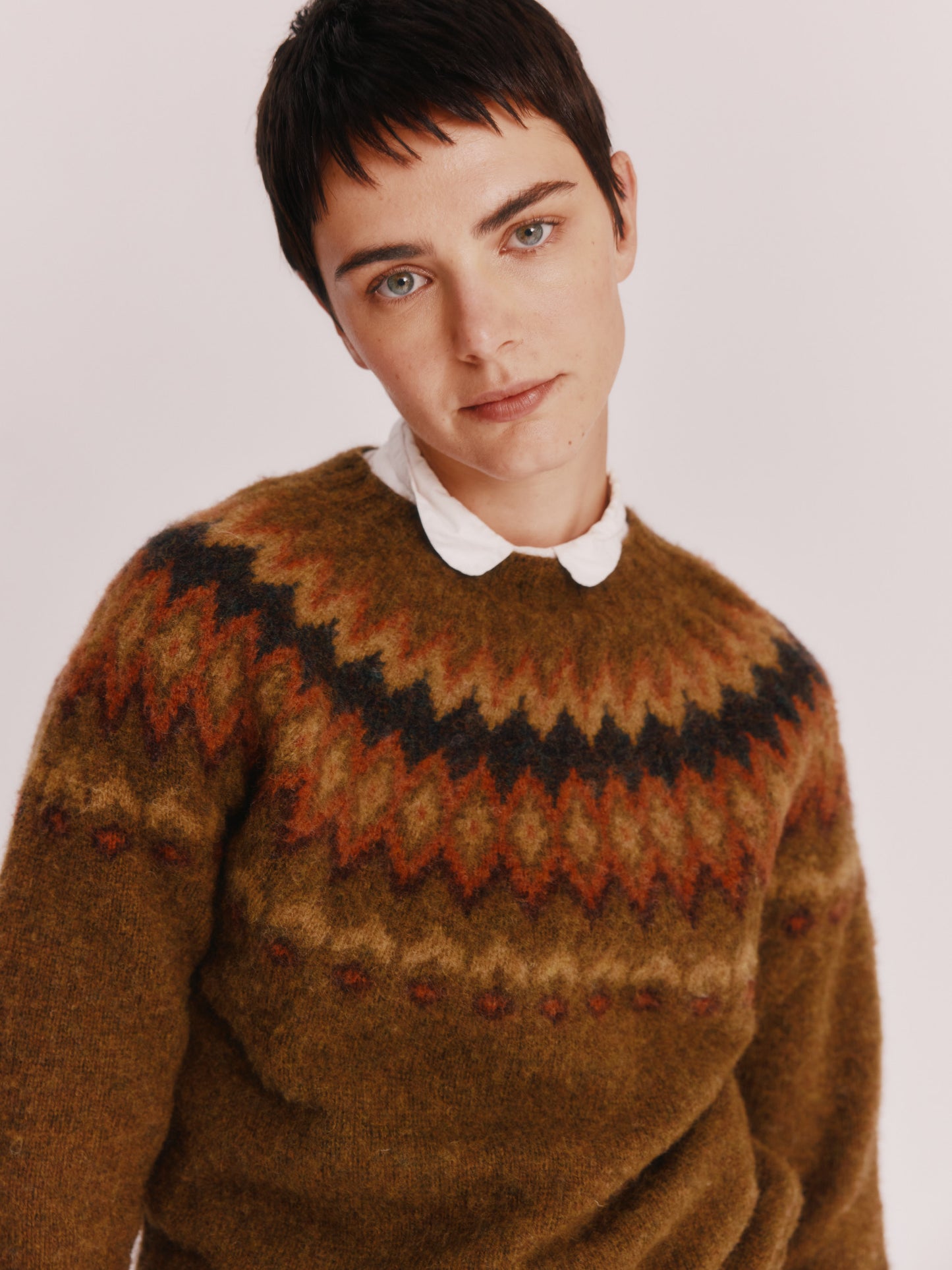 Model wearing a Bosie Knitwear Fjord Yoke Brushed Fair Isle Women's Lambswool Sweater in colour Dark Olive.
