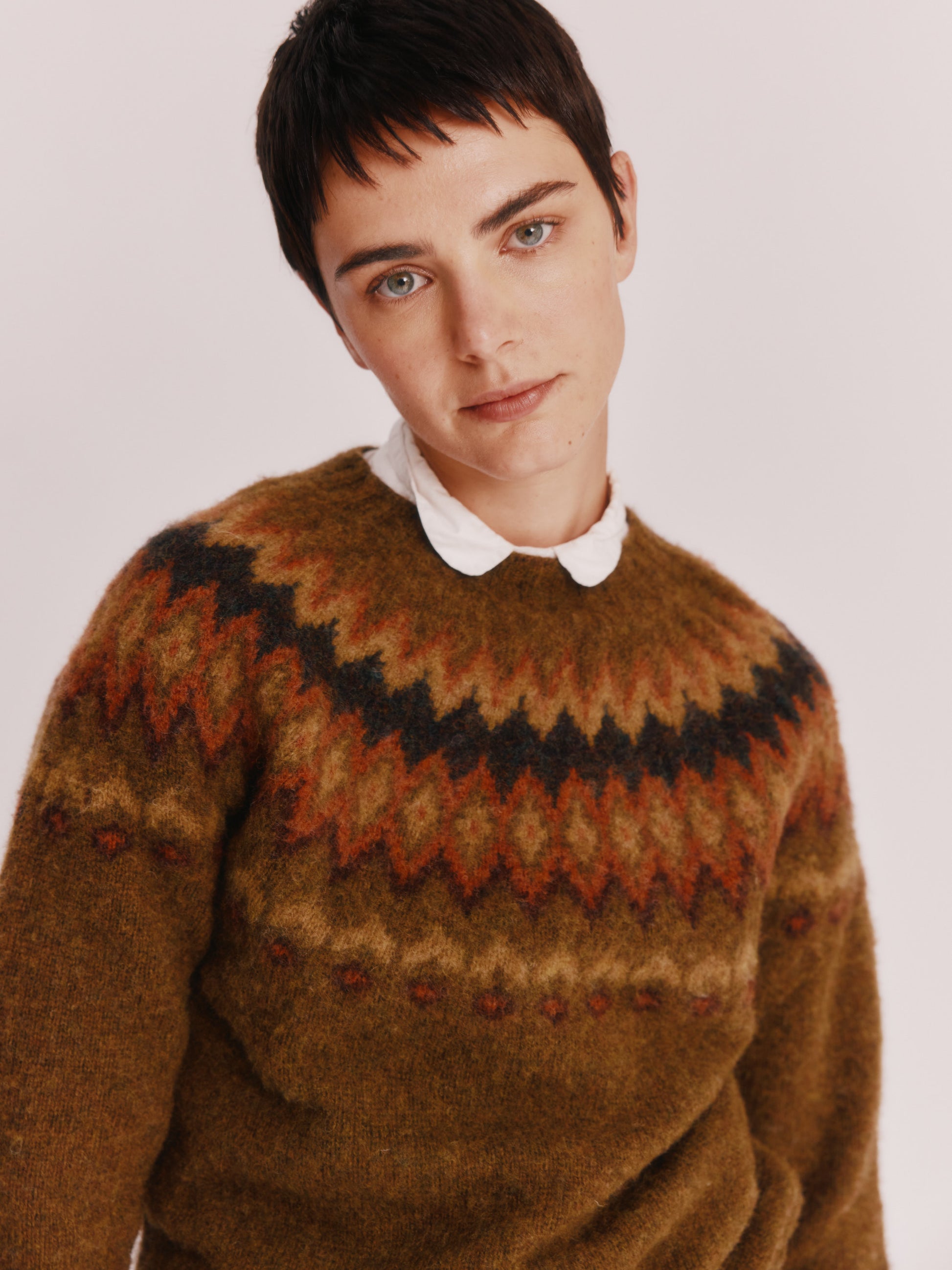 Model wearing a Bosie Knitwear Fjord Yoke Brushed Fair Isle Women's Lambswool Sweater in colour Dark Olive.