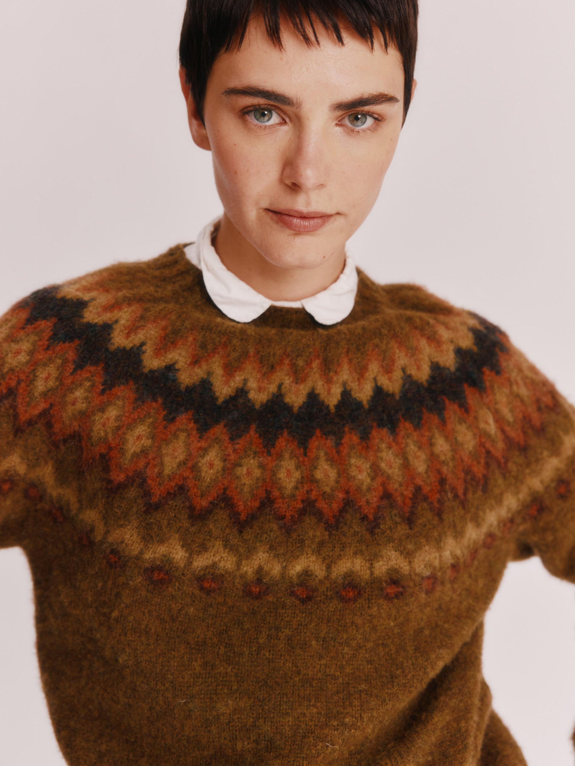 Model wearing a Bosie Knitwear Fjord Yoke Brushed Fair Isle Women's Lambswool Sweater in colour Dark Olive.