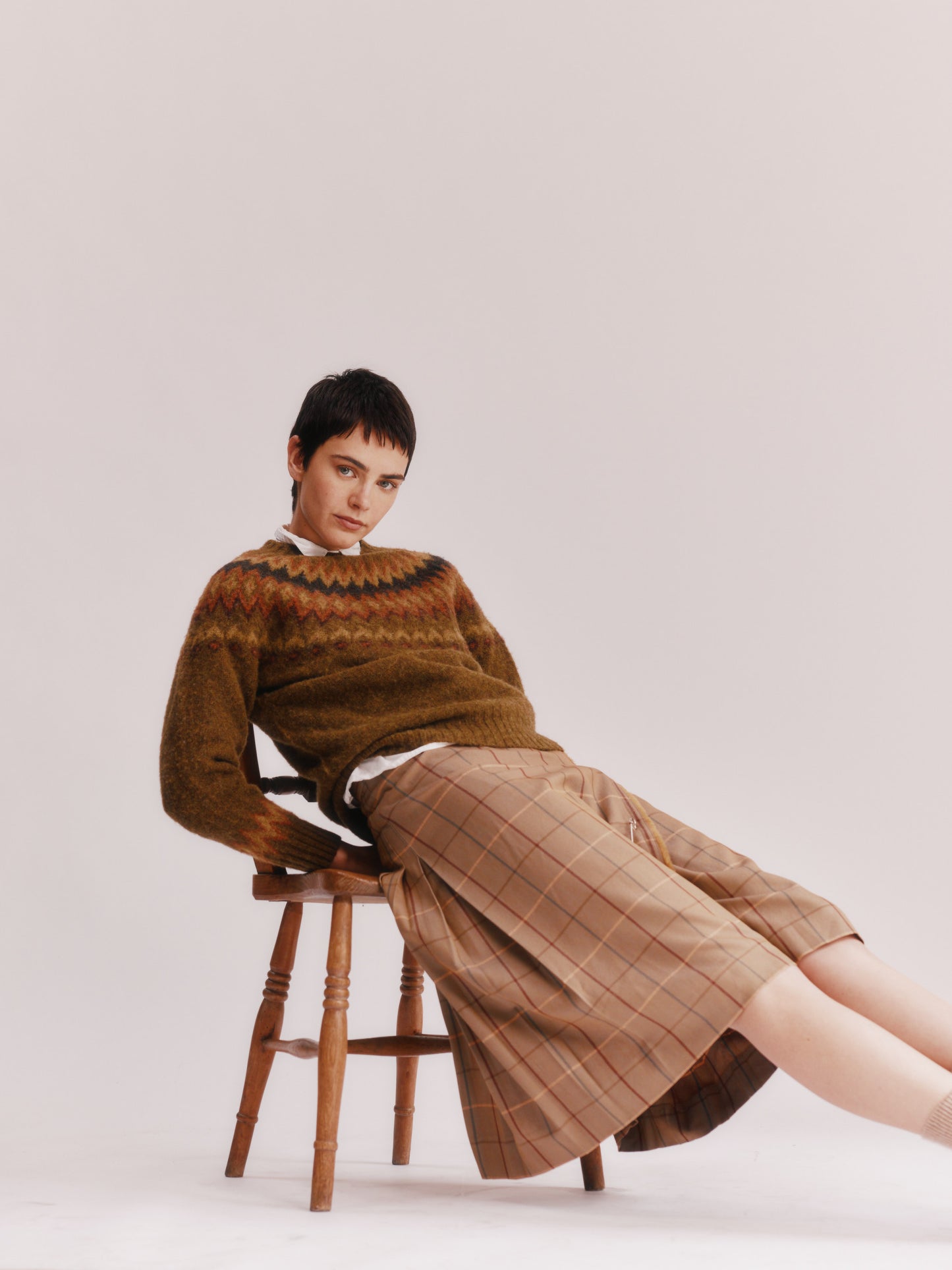 Model wearing a Bosie Knitwear Fjord Yoke Brushed Fair Isle Women's Lambswool Sweater in colour Dark Olive.