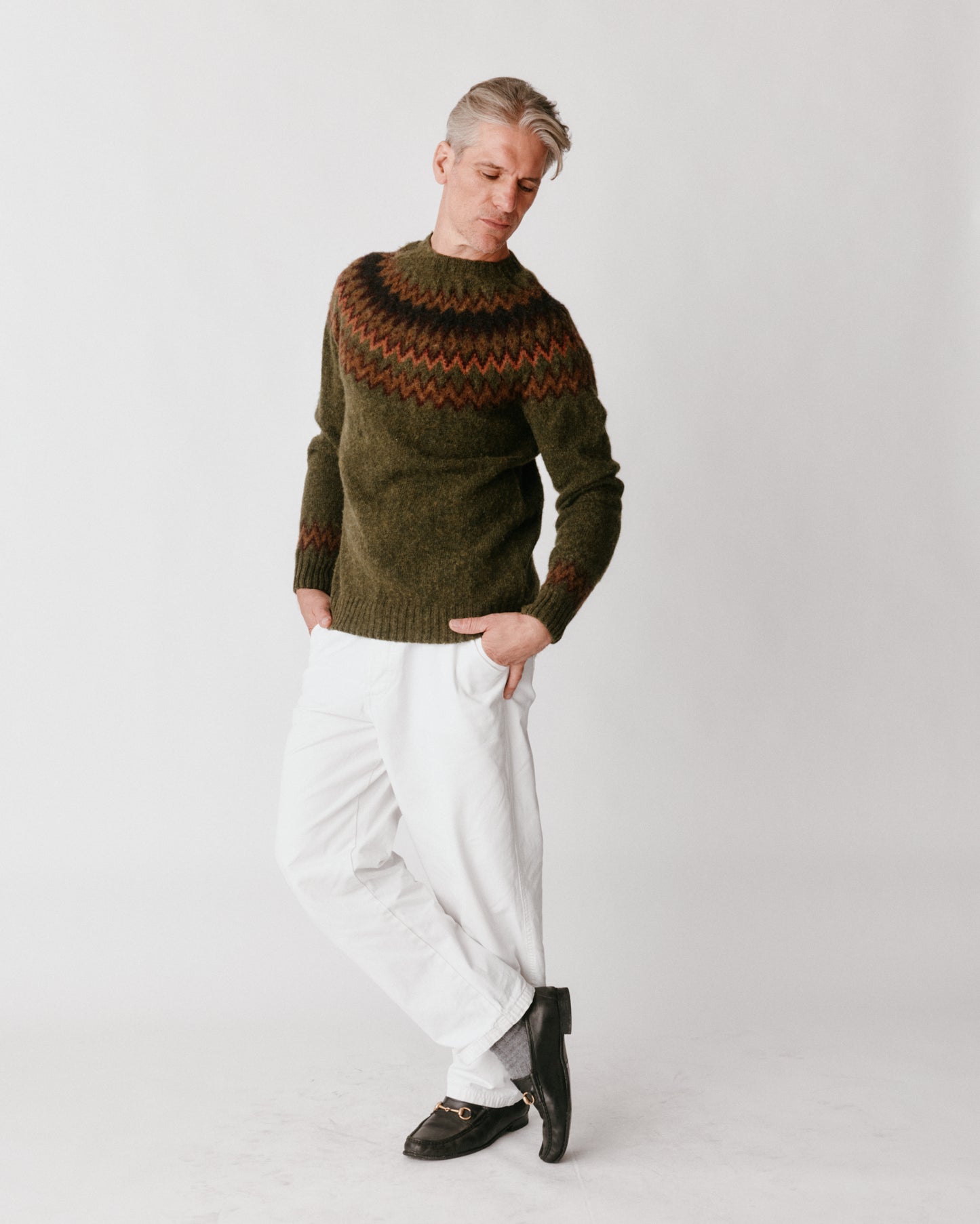 A model wearing a Bosie Glacier Yoke  Brushed Fair Isle Men's Sweater in colour Scots Pine / Pineshadow.