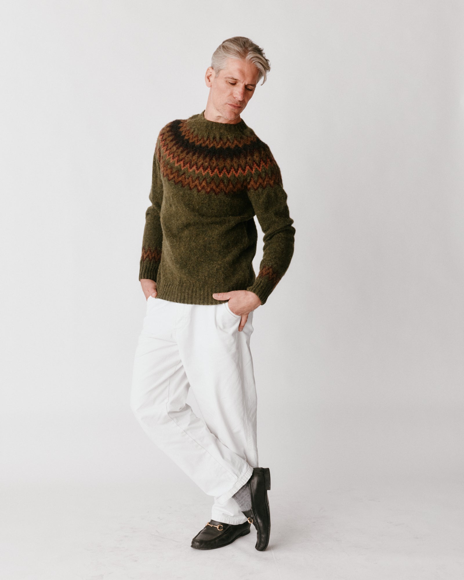 A model wearing a Bosie Glacier Yoke  Brushed Fair Isle Men's Sweater in colour Scots Pine / Pineshadow.