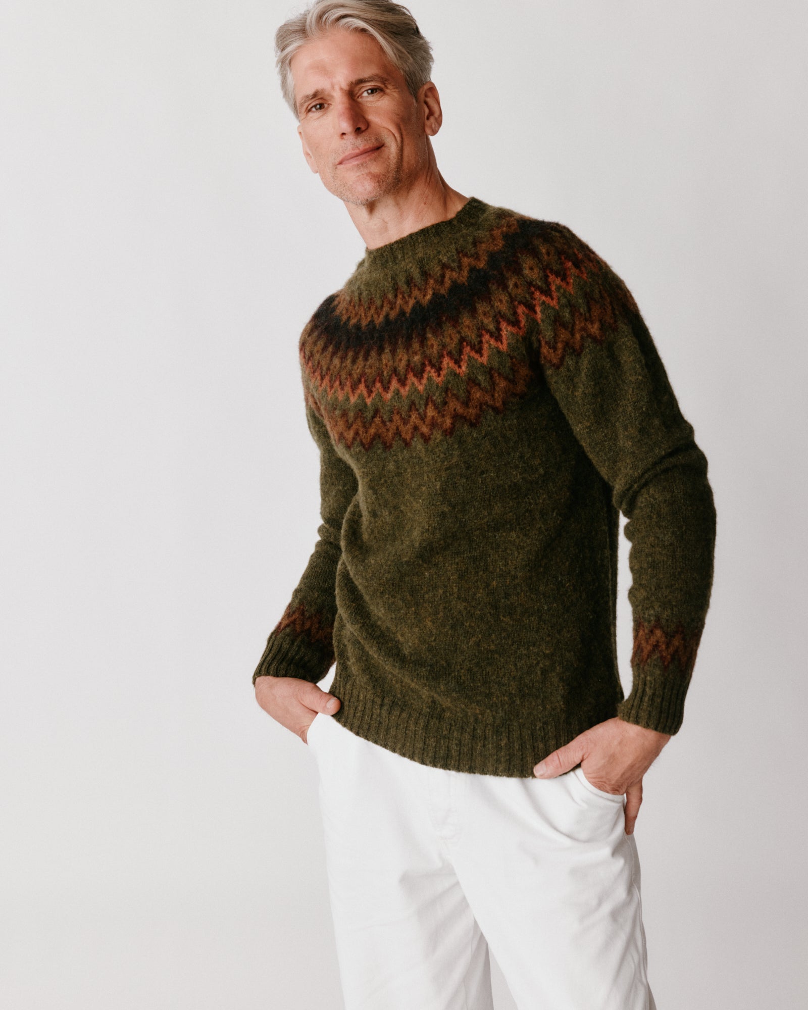 A model wearing a Bosie Glacier Yoke  Brushed Fair Isle Men's Sweater in colour Scots Pine / Pineshadow.