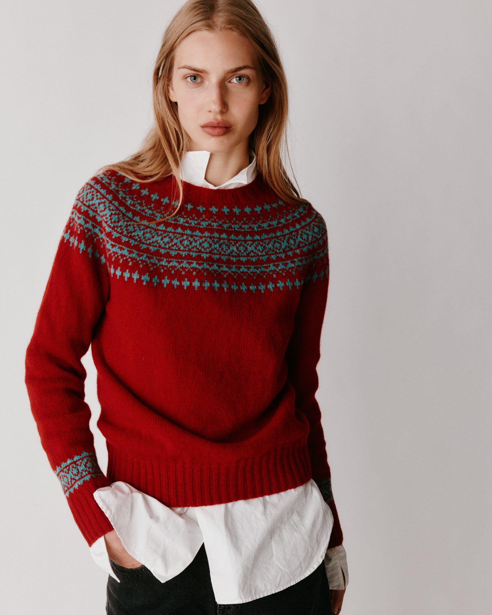 A model wearing a Bosie Hara Yoke Fair Isle Women's Sweater in colour Cardinal.