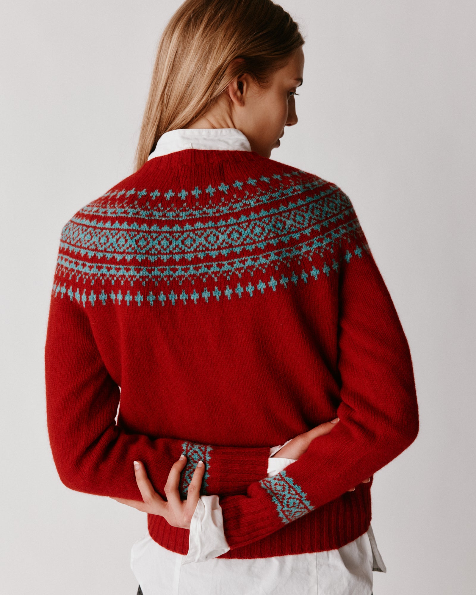 A model wearing a Bosie Hara Yoke Fair Isle Women's Sweater in colour Cardinal.
