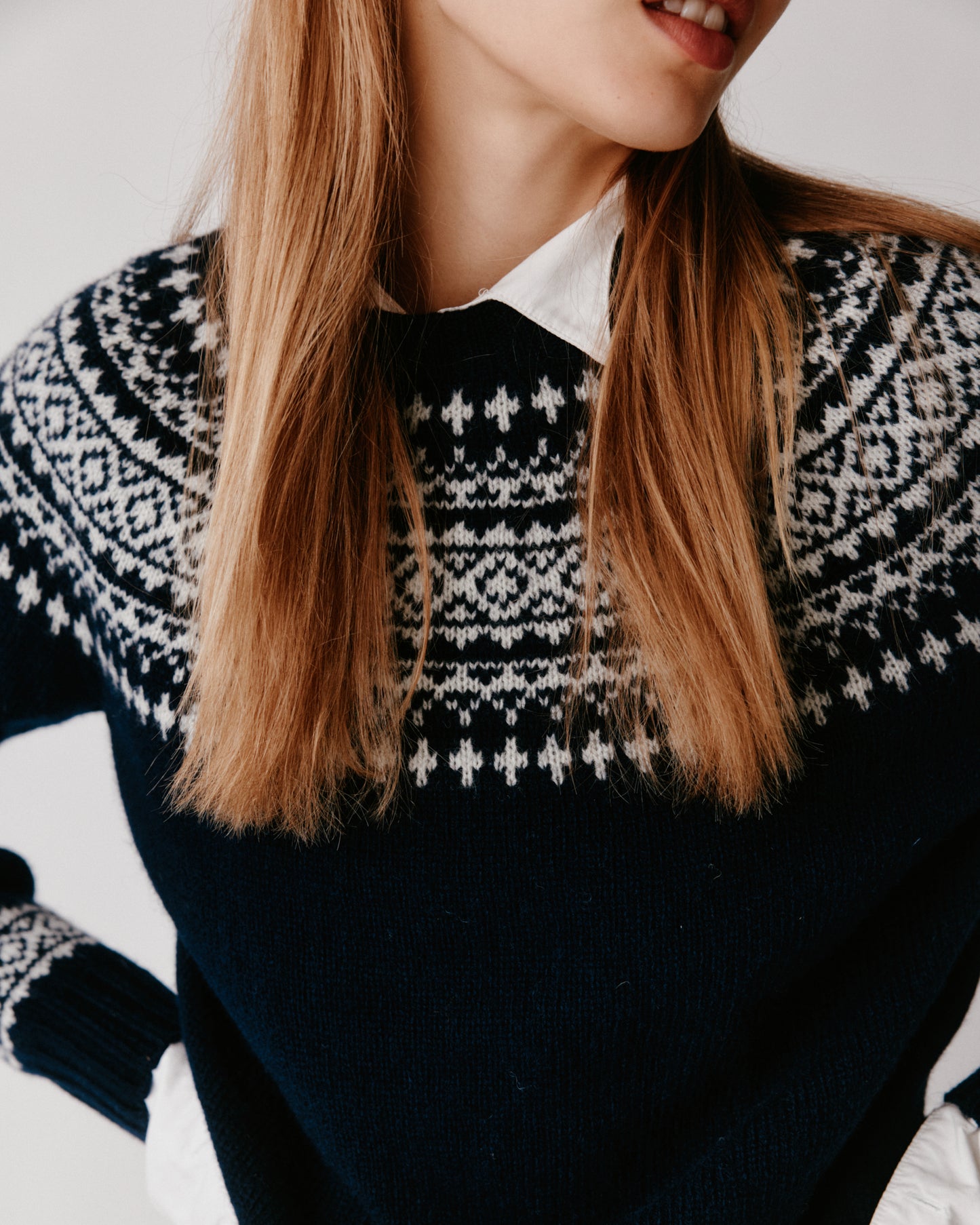 A model wearing a Bosie Hara Yoke Fair Isle Women's Sweater in colour Navy. 