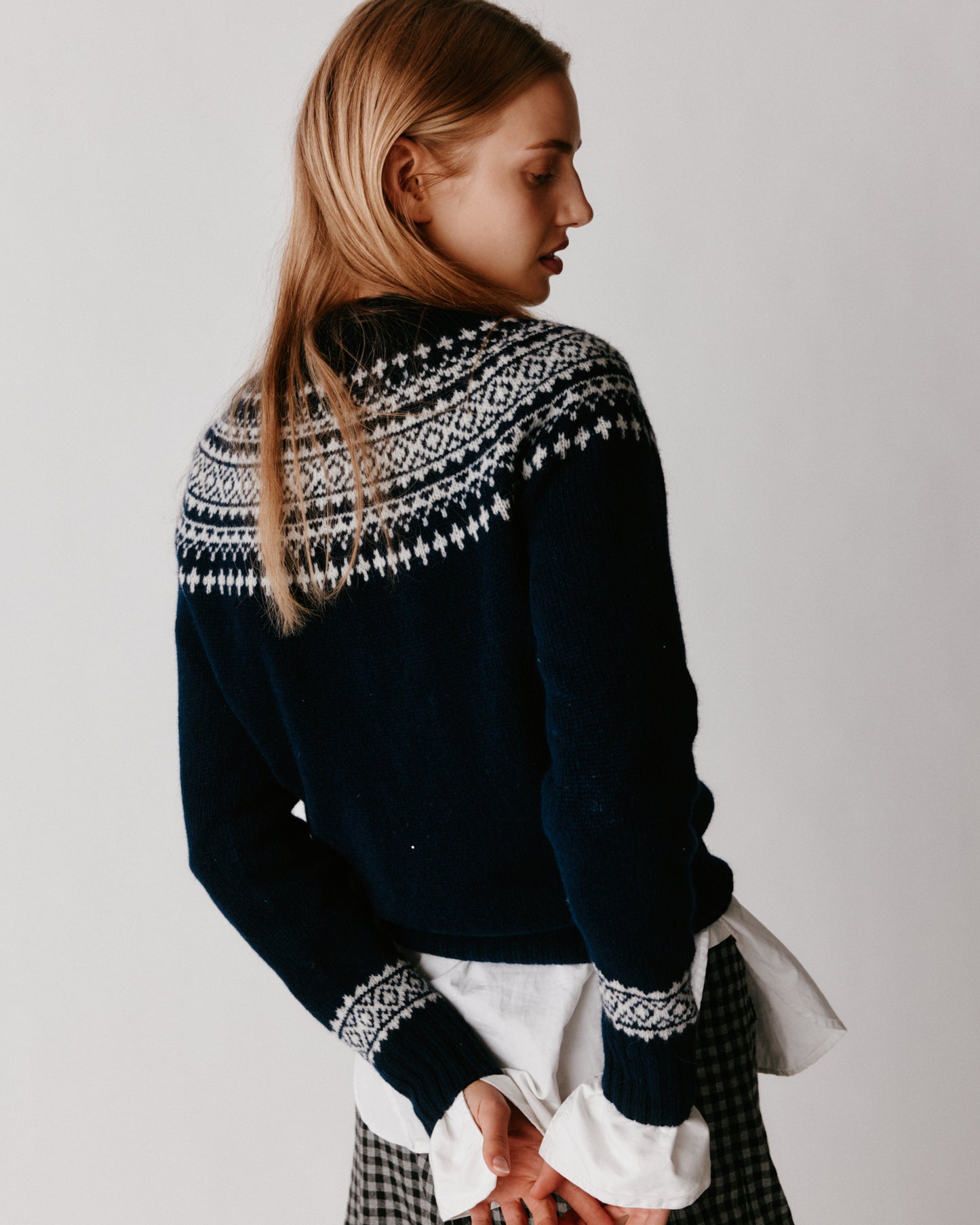 A model wearing a Bosie Hara Yoke Fair Isle Women's Sweater in colour Navy. 