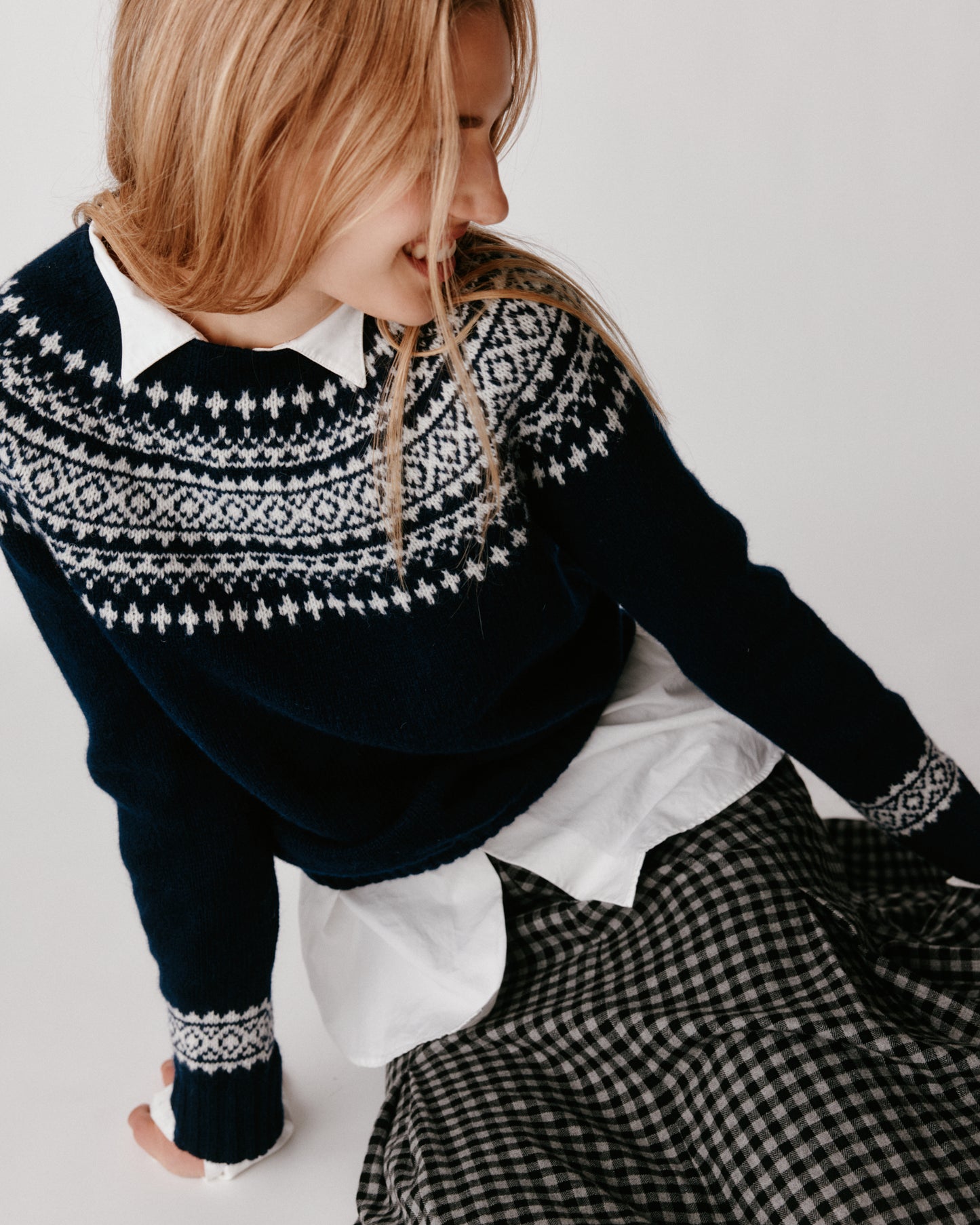 A model wearing a Bosie Hara Yoke Fair Isle Women's Sweater in colour Navy. 