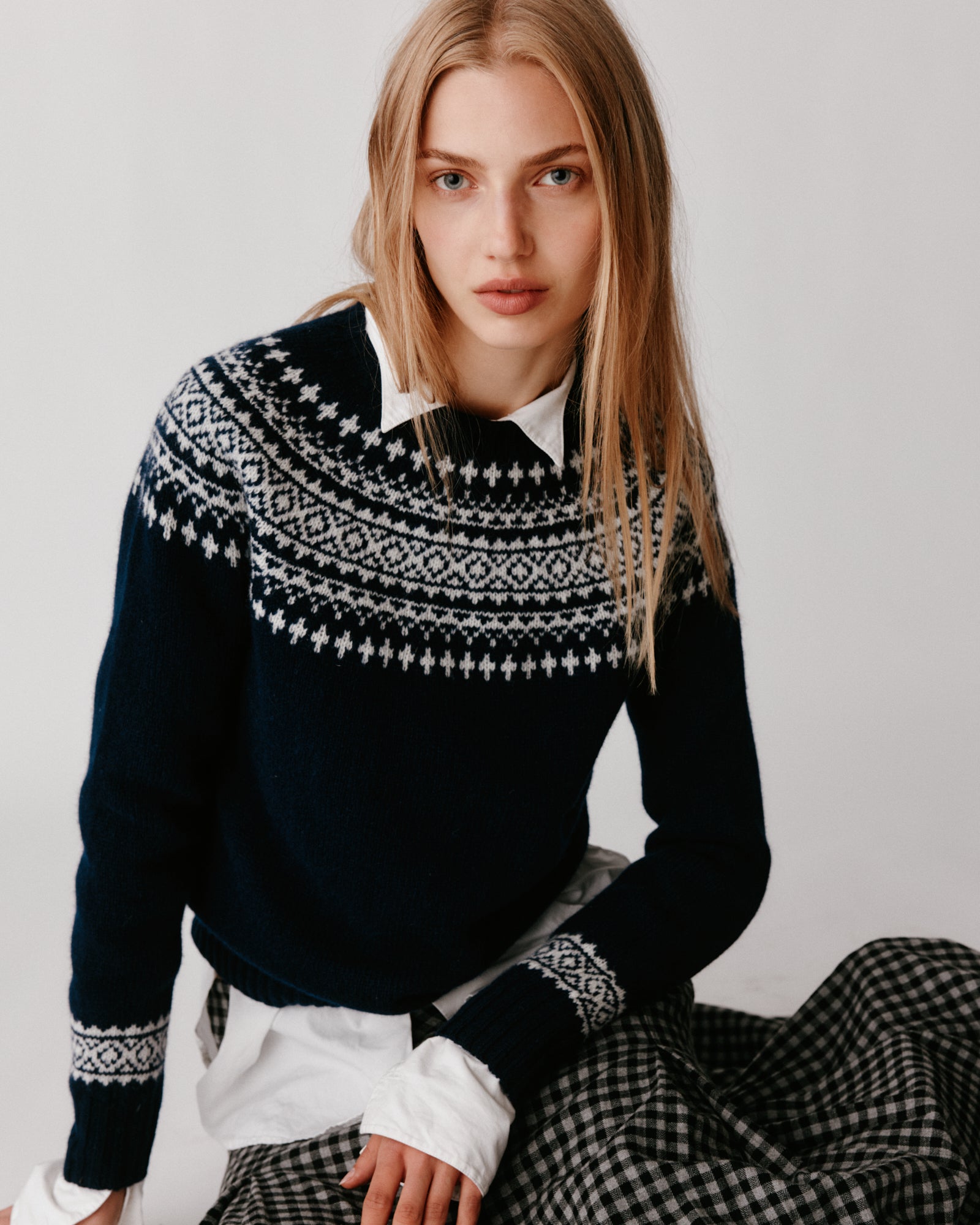 A model wearing a Bosie Hara Yoke Fair Isle Women's Sweater in colour Navy. 