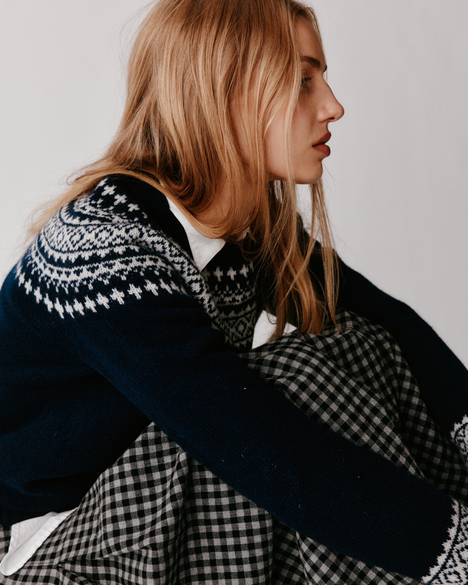 A model wearing a Bosie Hara Yoke Fair Isle Women's Sweater in colour Navy. 