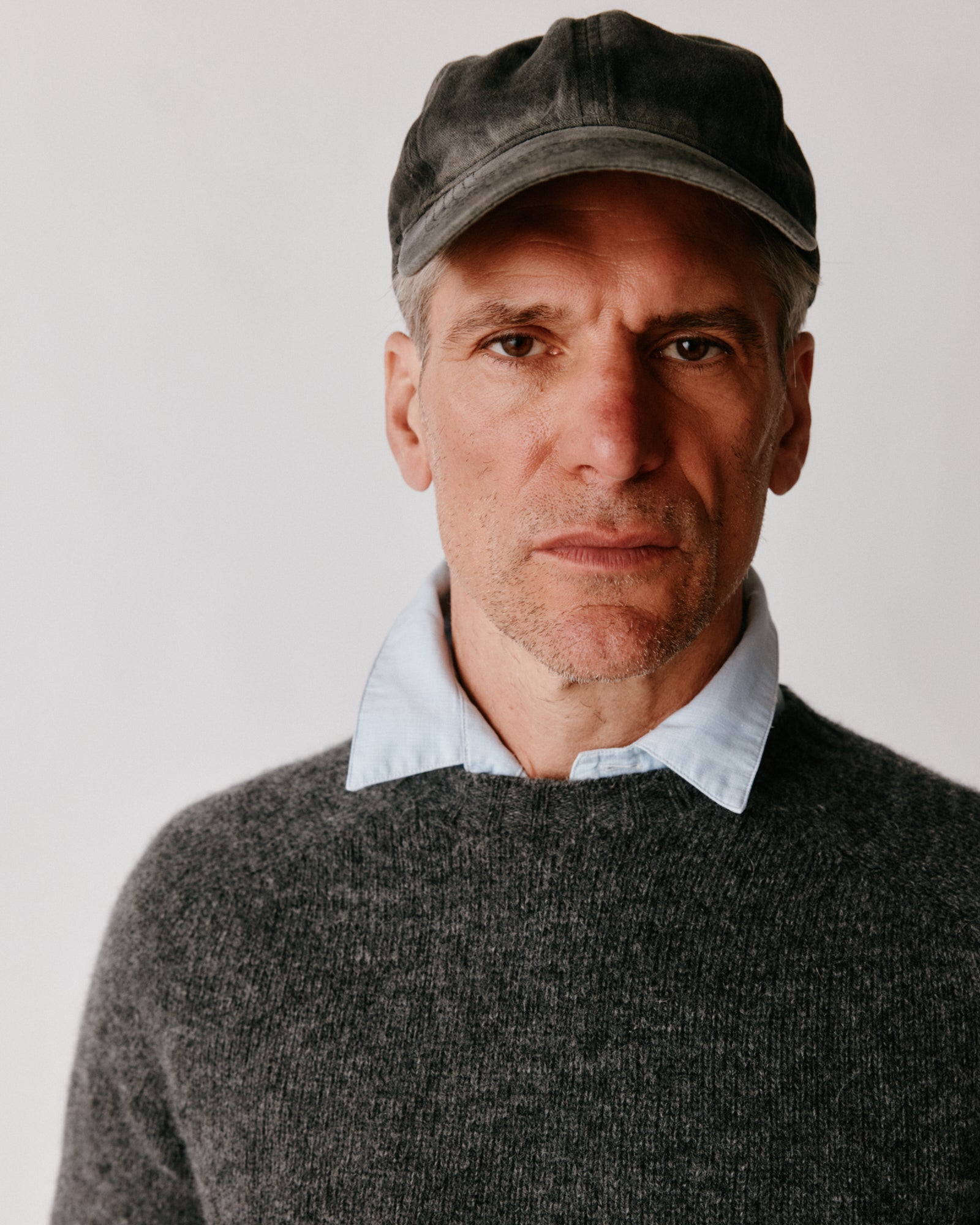 A model wearing a Harley of Scotland Mens Seamless Saddle Shoulder Shetland Sweater in colour Basalt / Oxford Grey.