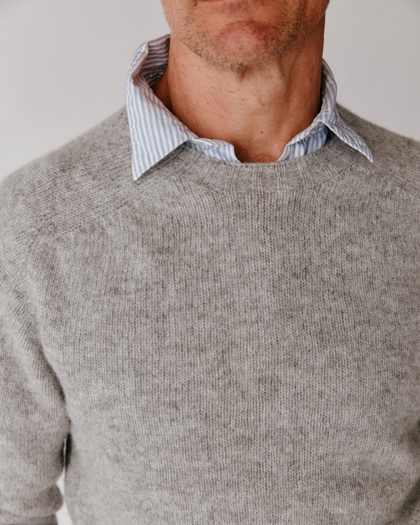 A model wearing a Bosie Harley of Scotland Mens Seamless Saddle Shoulder Shetland Sweater in colour Silver.