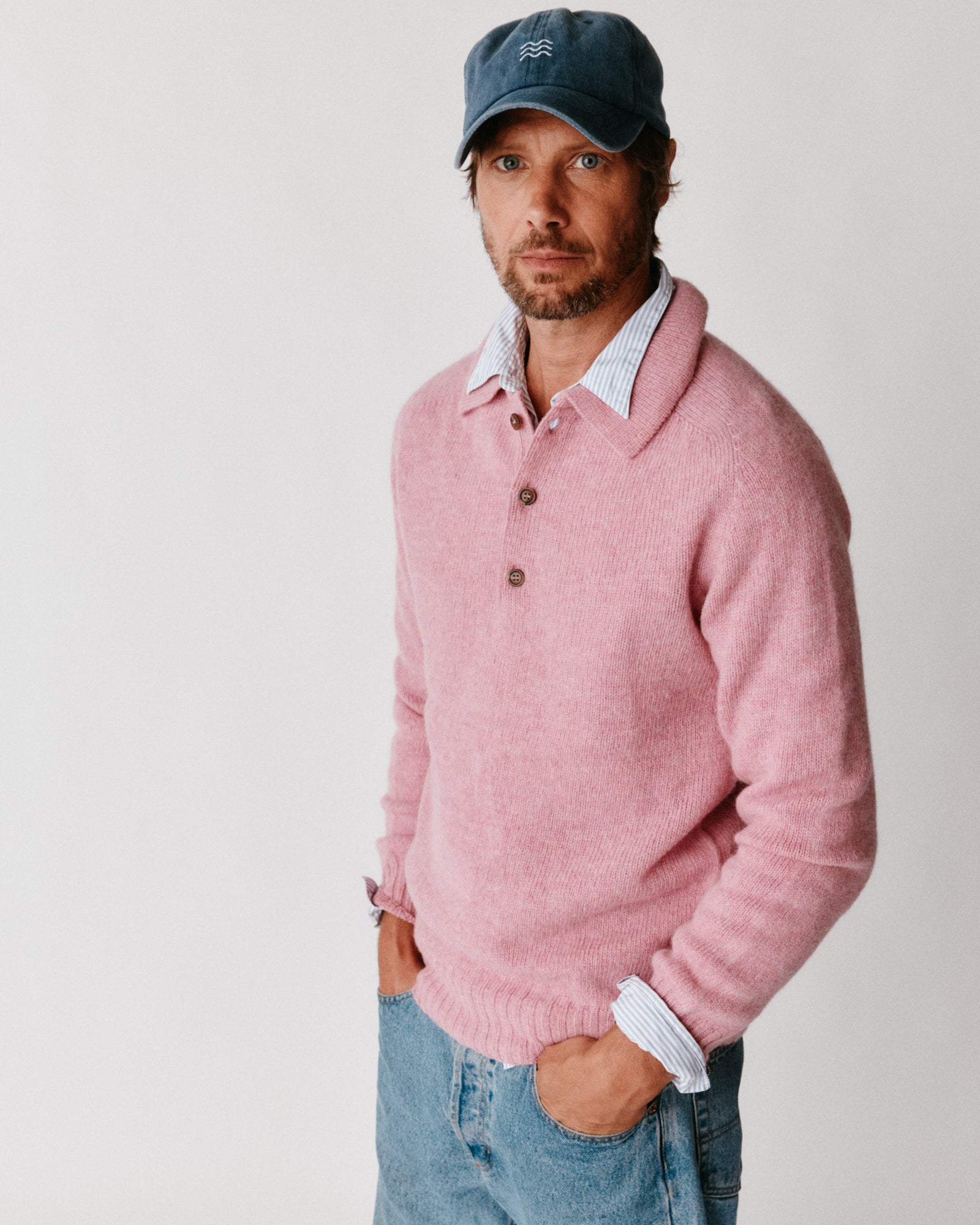 A model wearing a Bosie Harley of Scotland Mens Shetland Eton Collar Sweater in colour Sakura / Bosie Pink.