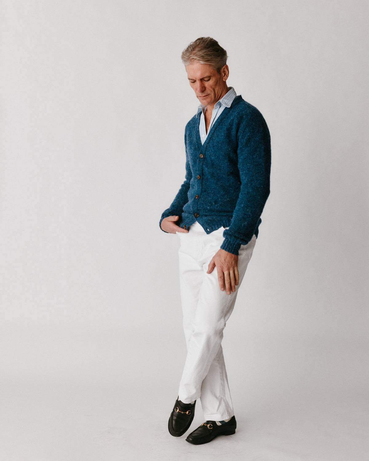 A model wearing a Bosie Harley of Scotland Shaggy Shetland Men's V Cardigan in colour Denim.