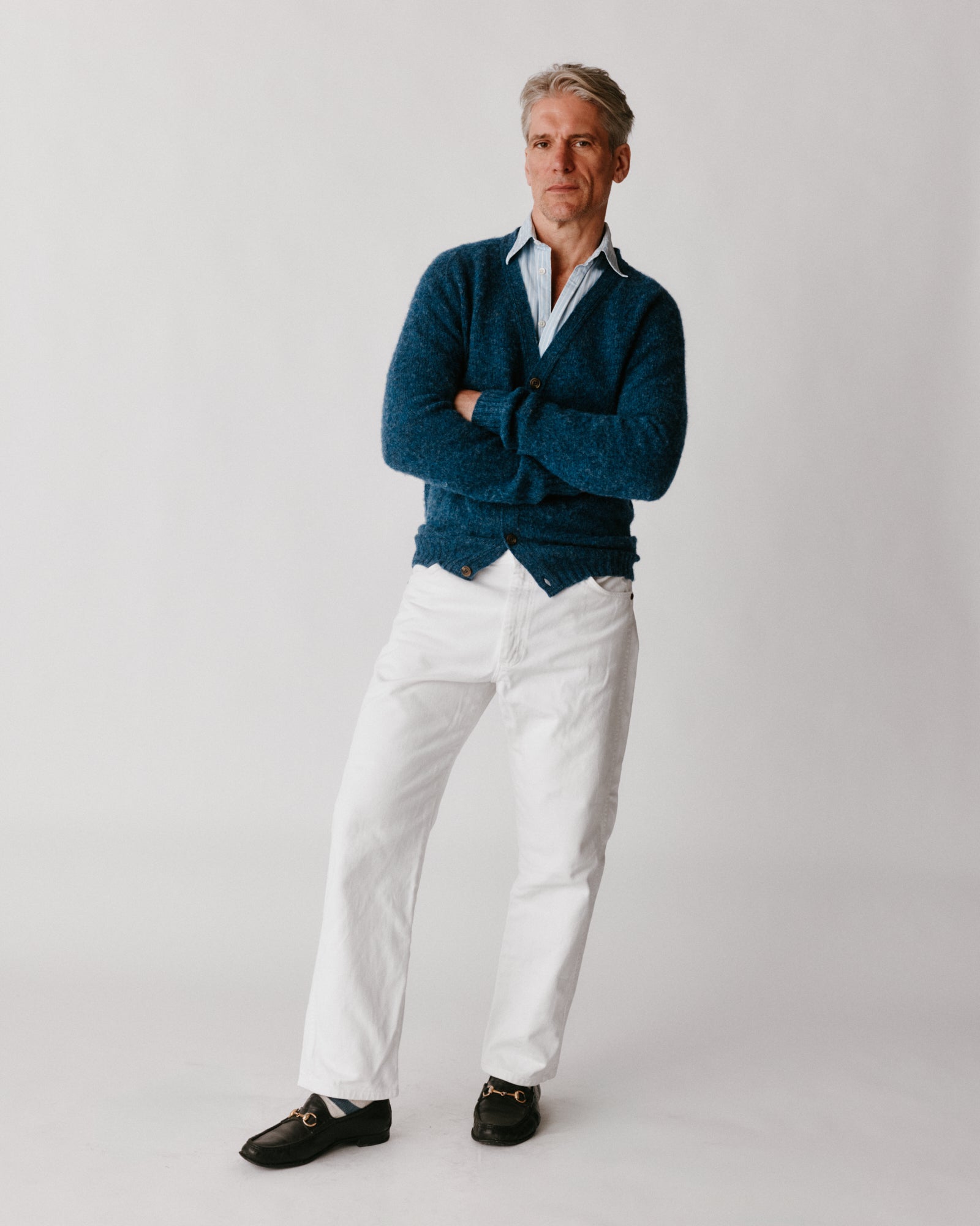 A model wearing a Bosie Harley of Scotland Shaggy Shetland Men's V Cardigan in colour Denim.