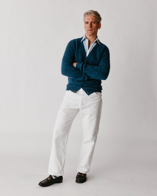 A model wearing a Bosie Harley of Scotland Shaggy Shetland Men's V Cardigan in colour Denim.