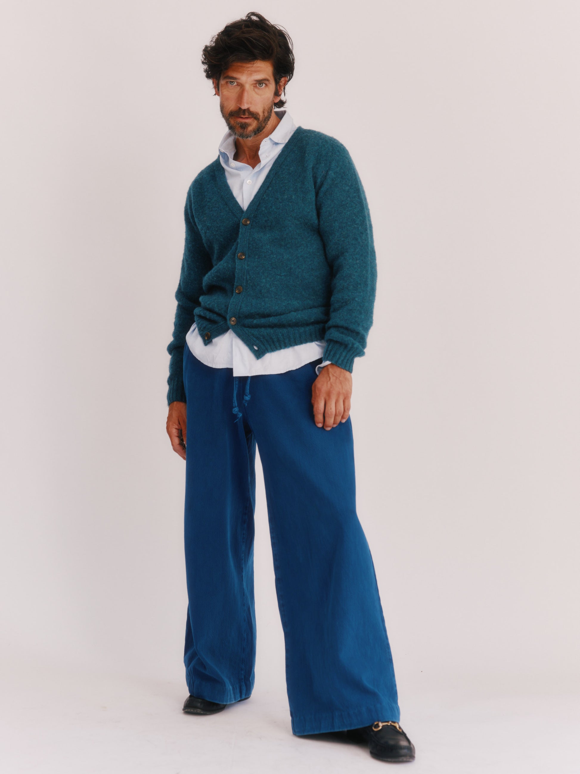 Model wearing a Harley of Scotland Shaggy Shetland Men's V Cardigan in colour Storm Dark Teal. 