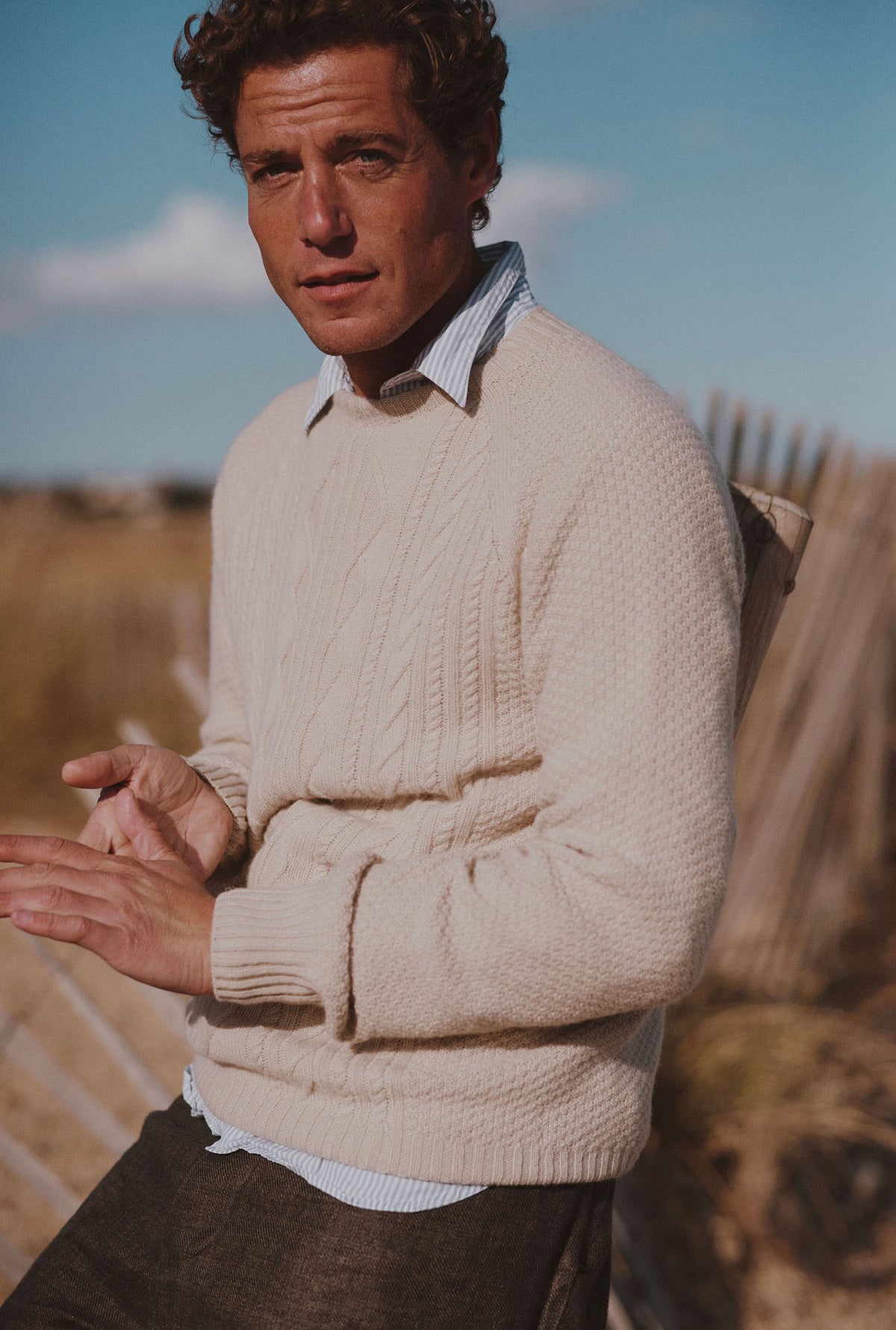 Man on a beach wearing a Bosie Knitwear Harley x Todd and Duncan Pure Cashmere Cable Sweater