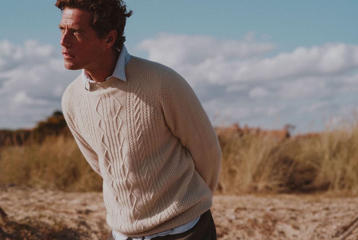 Man on a beach wearing a Bosie Knitwear Harley x Todd and Duncan Pure Cashmere Cable Sweater