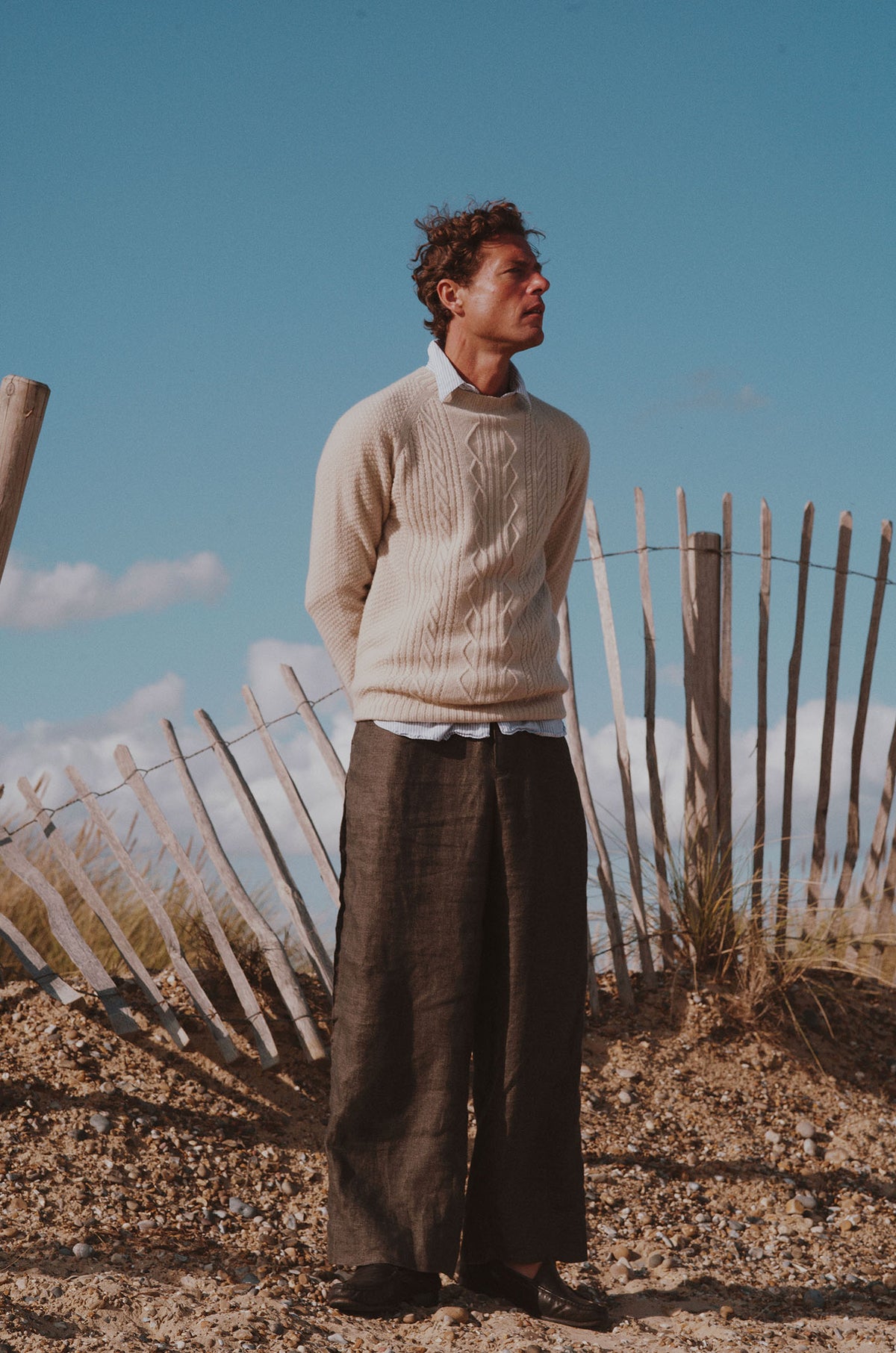 Man on a beach wearing a Bosie Knitwear Harley x Todd and Duncan Pure Cashmere Cable Sweater