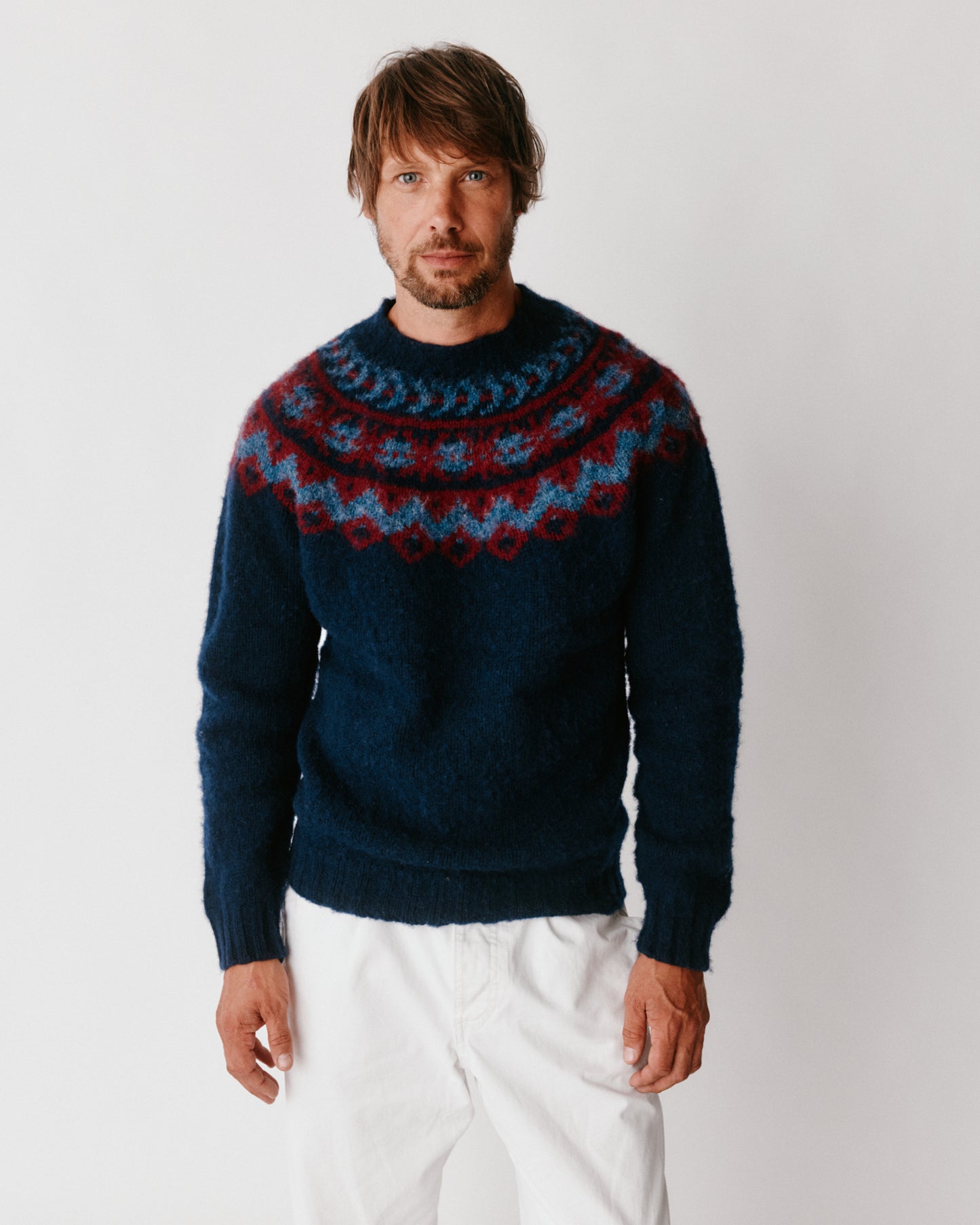 A model wearing a Bosie Highland Brushed Fairisle Yoke Lambswool Sweater in colour Navy.