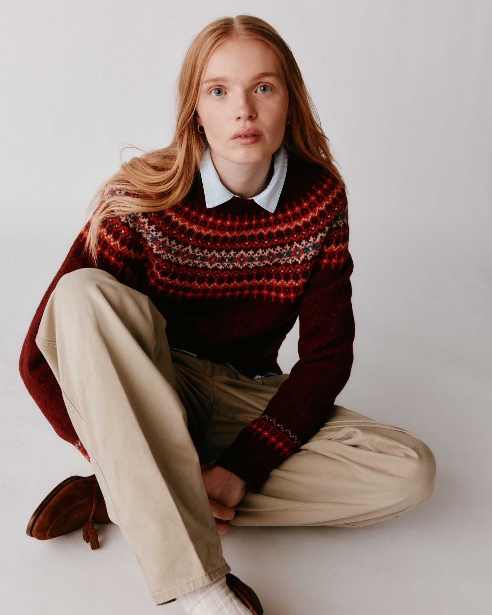 A model wearing a Bosie Islander Yoke Fair Isle Glenugie Nep Women's Sweater in colour Tiree Red.