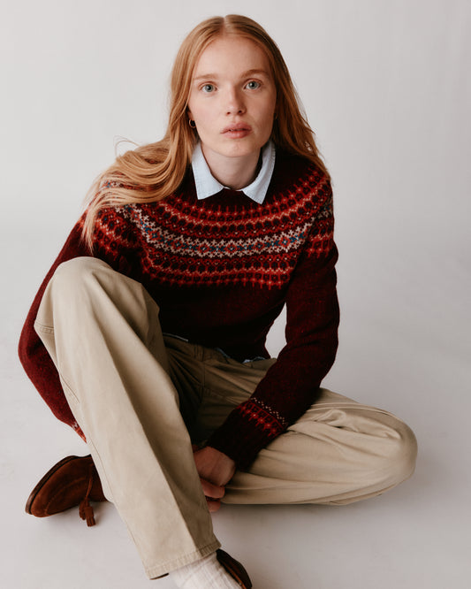 A model wearing a Bosie Islander Yoke Fair Isle Glenugie Nep Women's Sweater in colour Tiree Red.