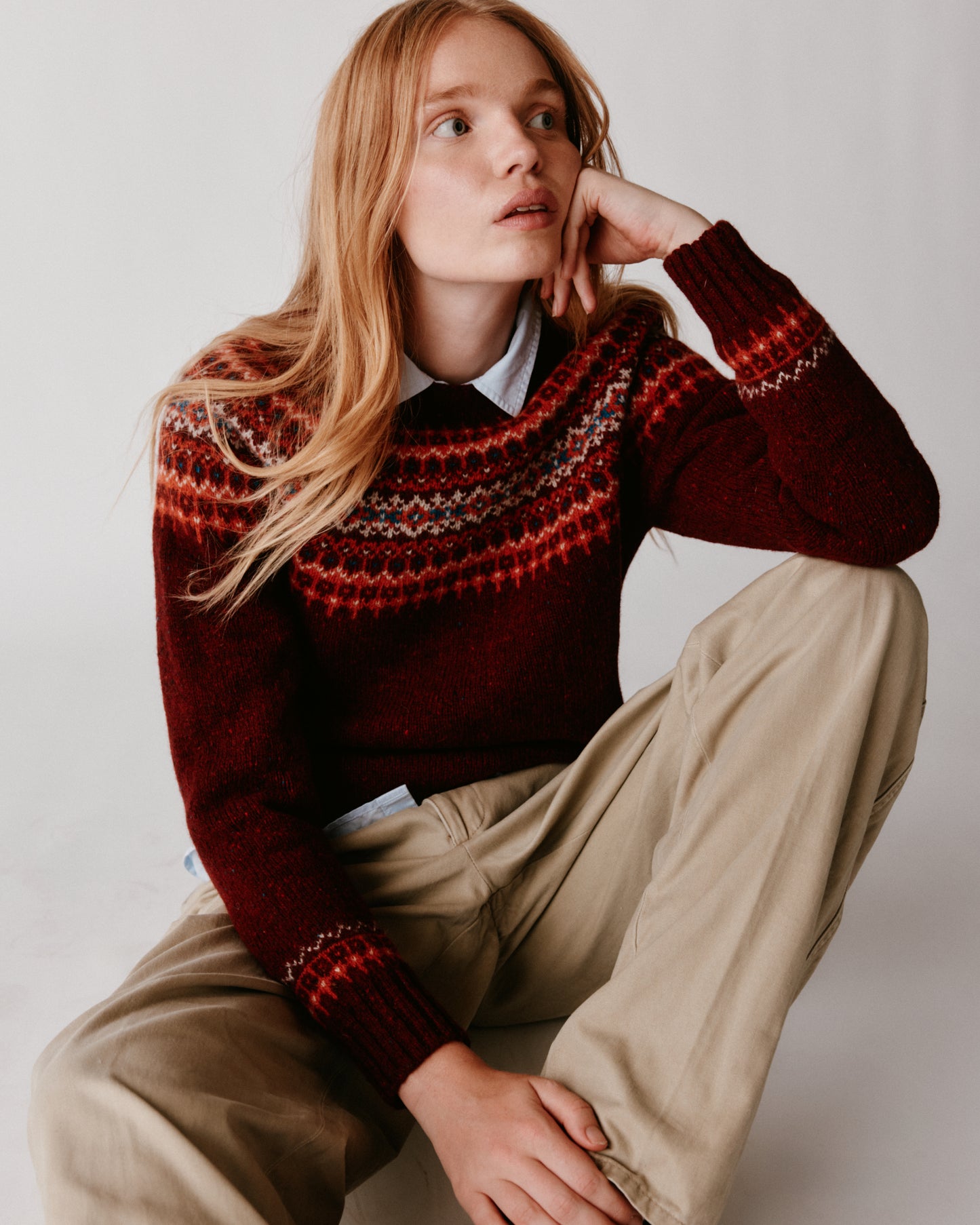 A model wearing a Bosie Islander Yoke Fair Isle Glenugie Nep Women's Sweater in colour Tiree Red.