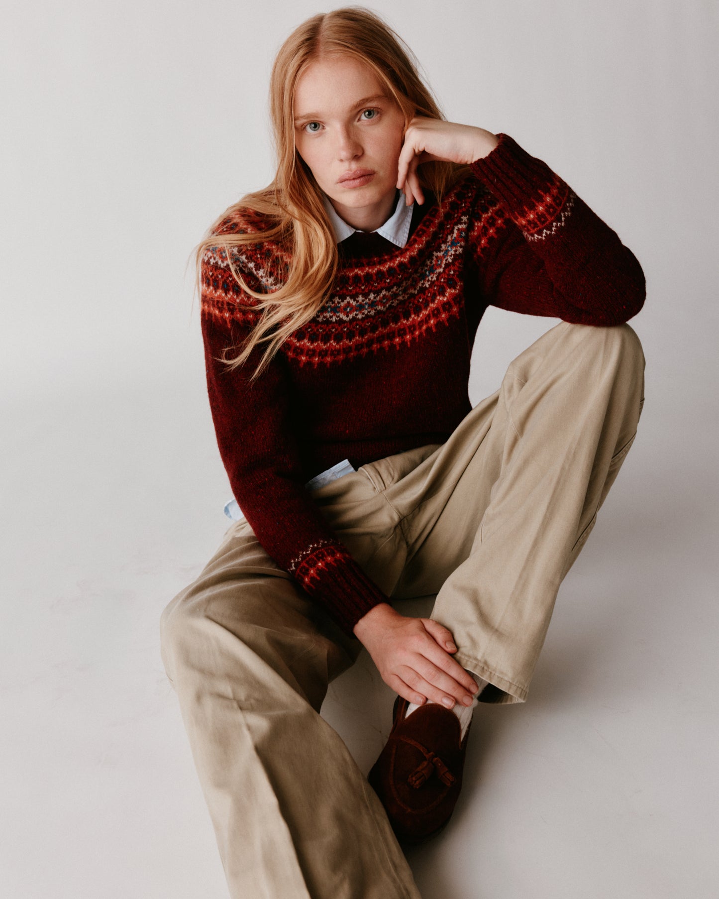 A model wearing a Bosie Islander Yoke Fair Isle Glenugie Nep Women's Sweater in colour Tiree Red.