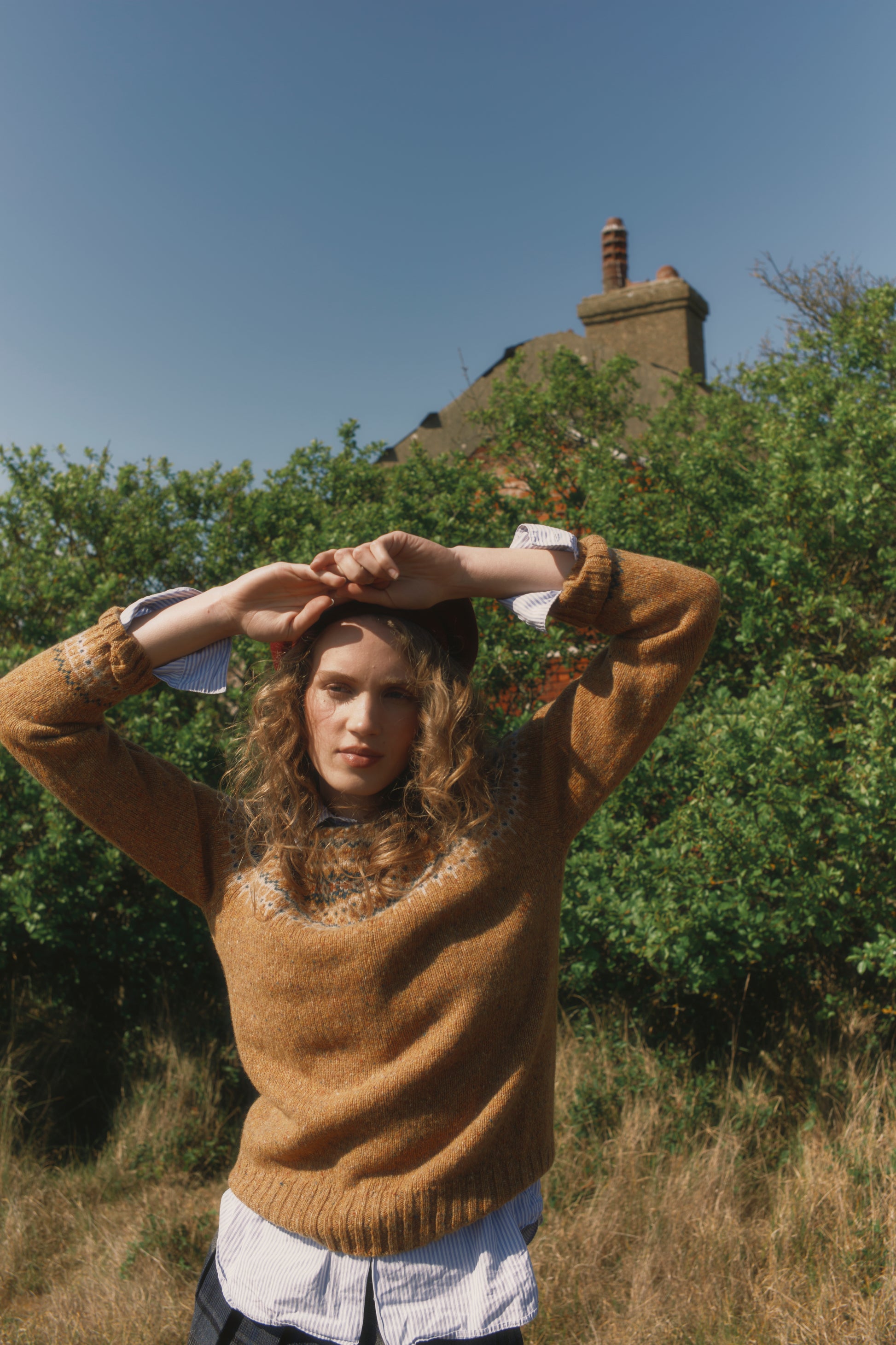 Model wearing a Bosie Knitwear Islander Yoke Fair Isle Glenugie Nep Women's Sweater in colour Barra Gold.
