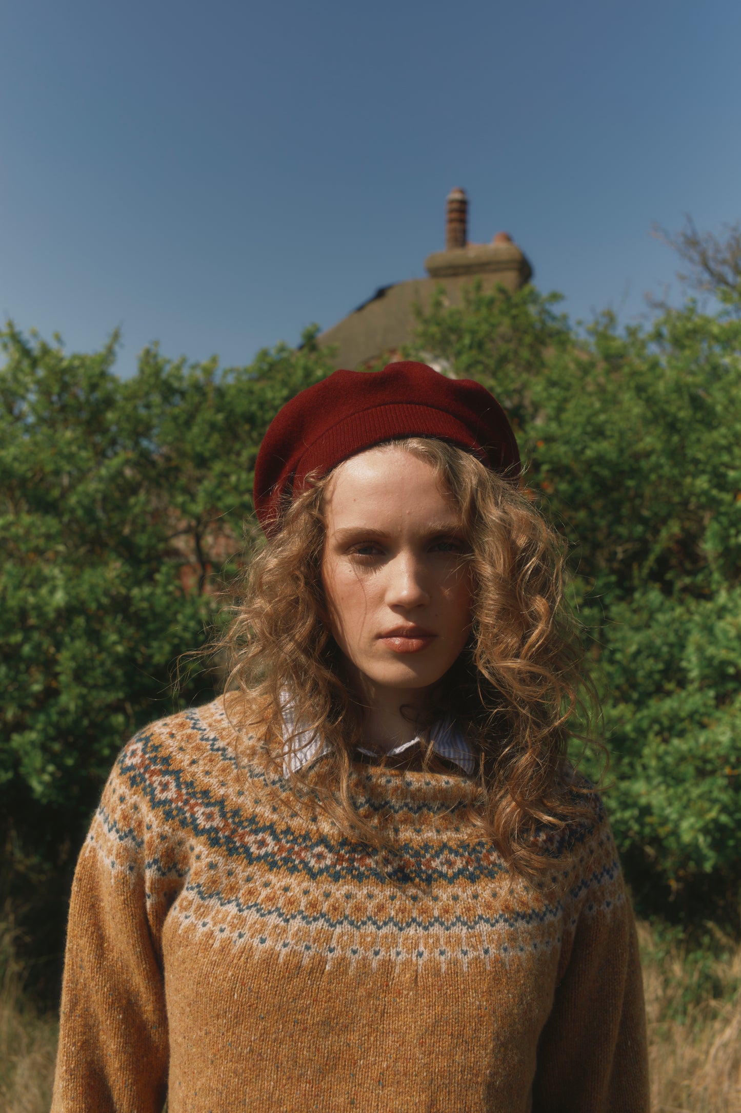 Model wearing a Bosie Knitwear Islander Yoke Fair Isle Glenugie Nep Women's Sweater in colour Barra Gold.