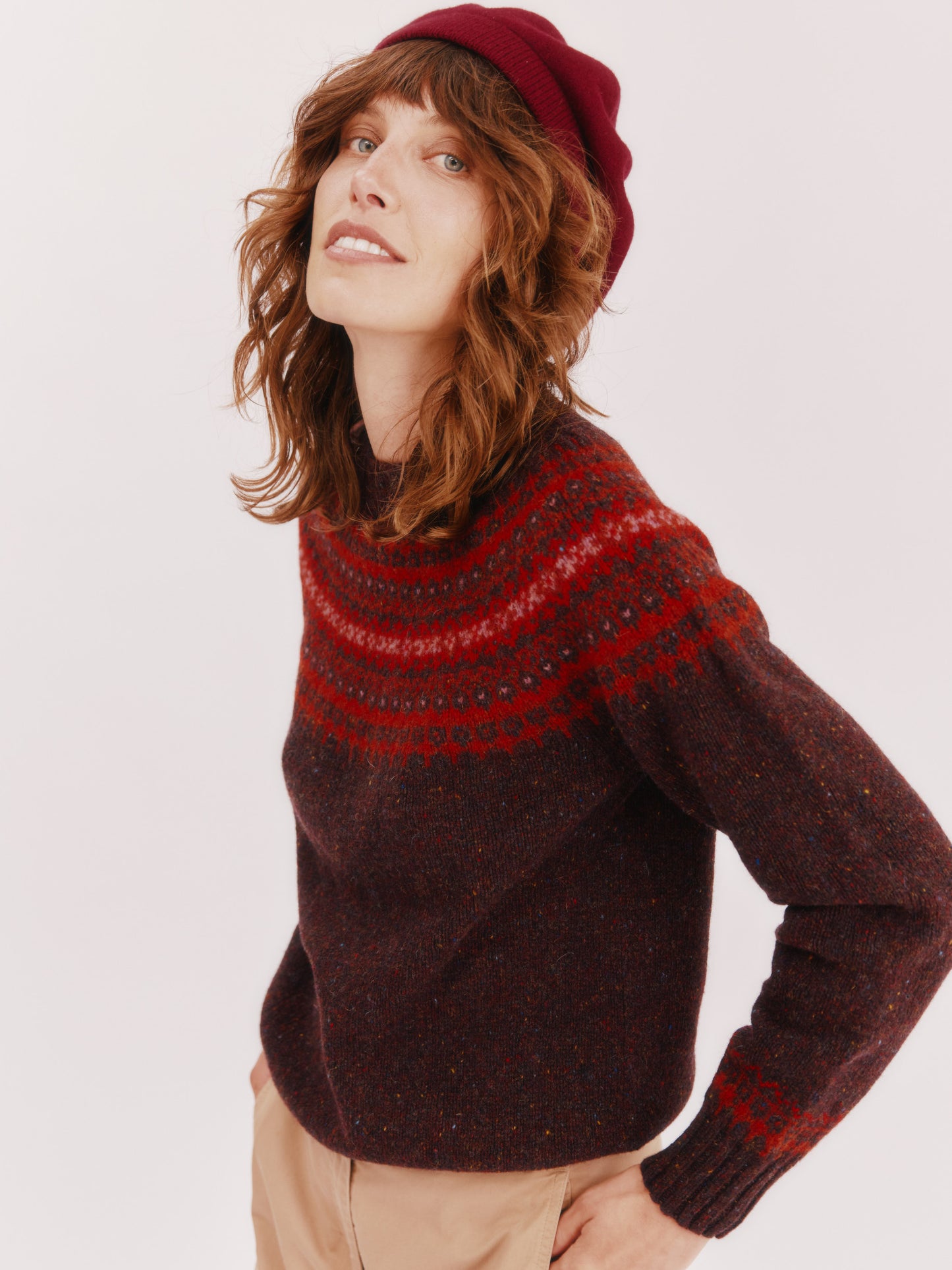 Model wearing a Bosie Knitwear Islander Yoke Fair Isle Glenugie Nep Women's Sweater in colour Lewis Dark Aubergine.