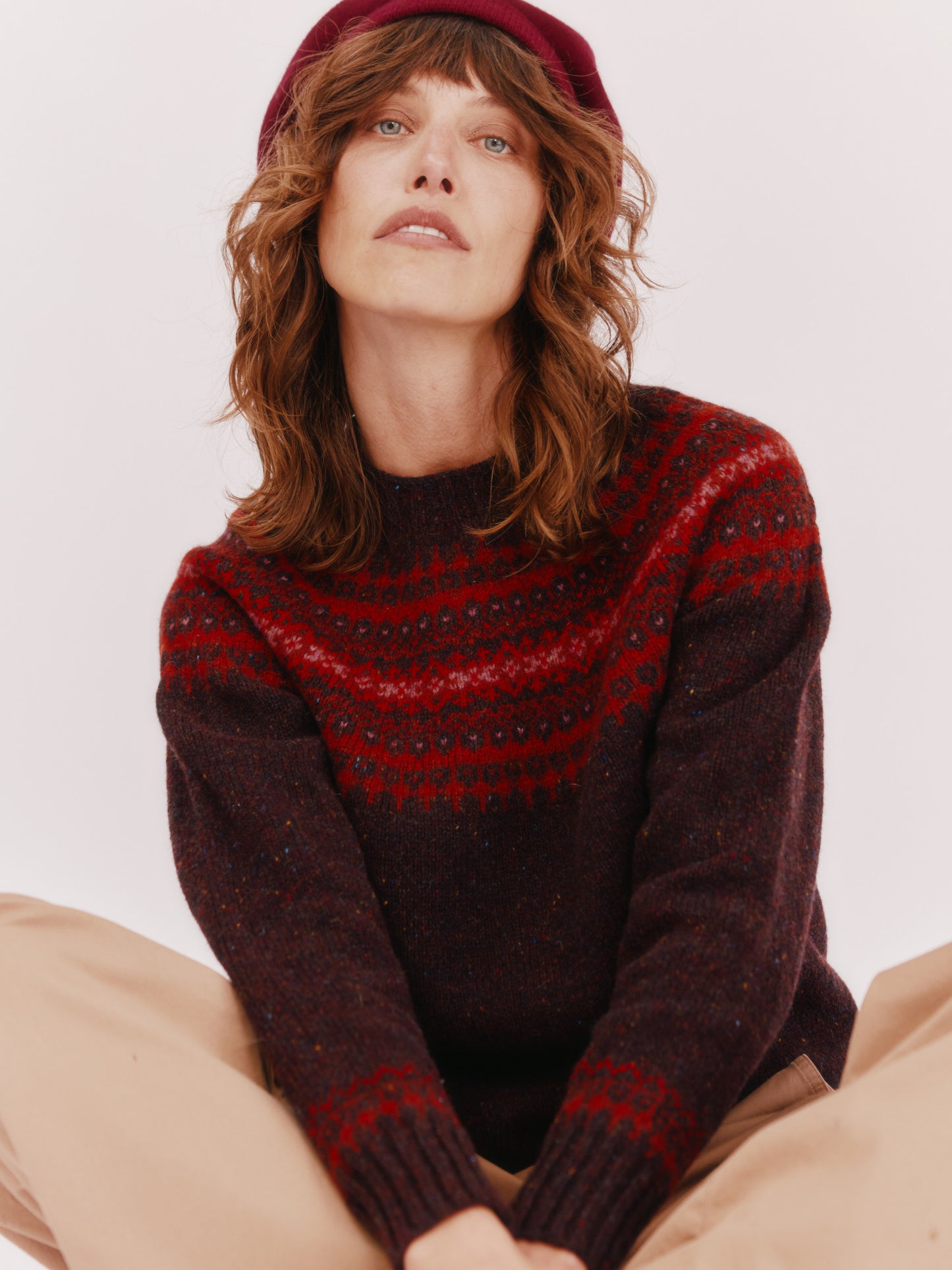 Model wearing a Bosie Knitwear Islander Yoke Fair Isle Glenugie Nep Women's Sweater in colour Lewis Dark Aubergine.